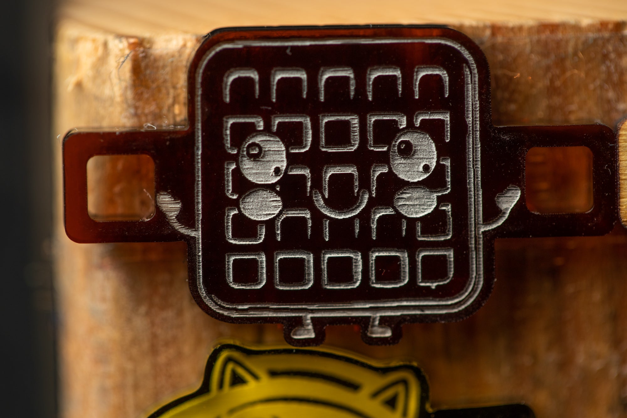 a close-up view of a brown object with a face, possibly a toy or a decoration, attached to a wooden surface.