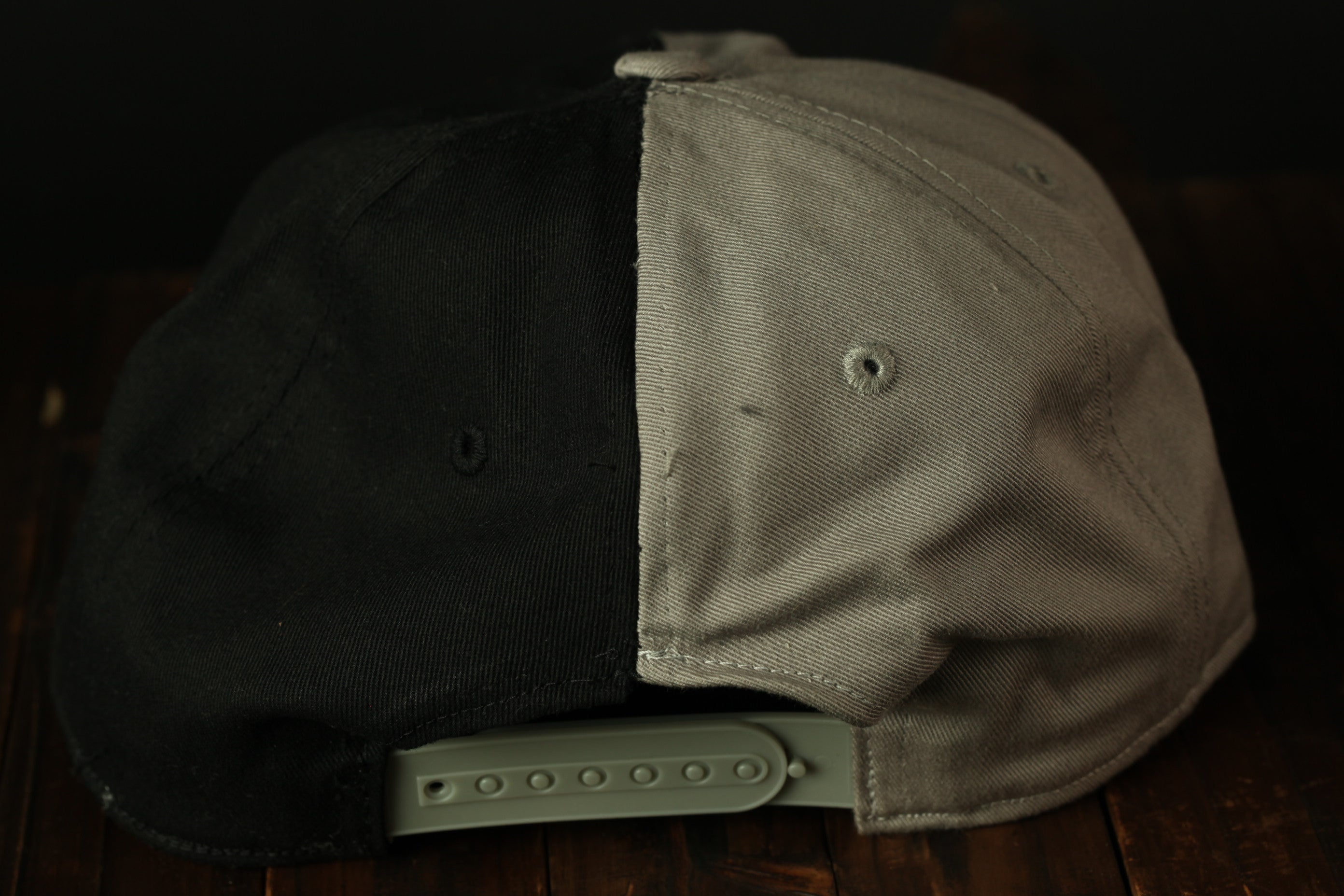 A black and gray baseball cap is shown in the image, with the black section appearing to be the brim and the gray section being the front.