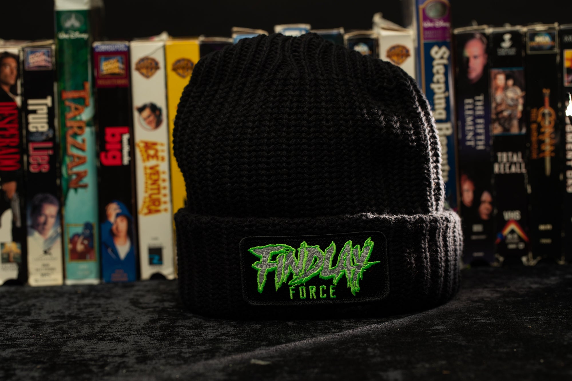a black beanie with a green logo on it