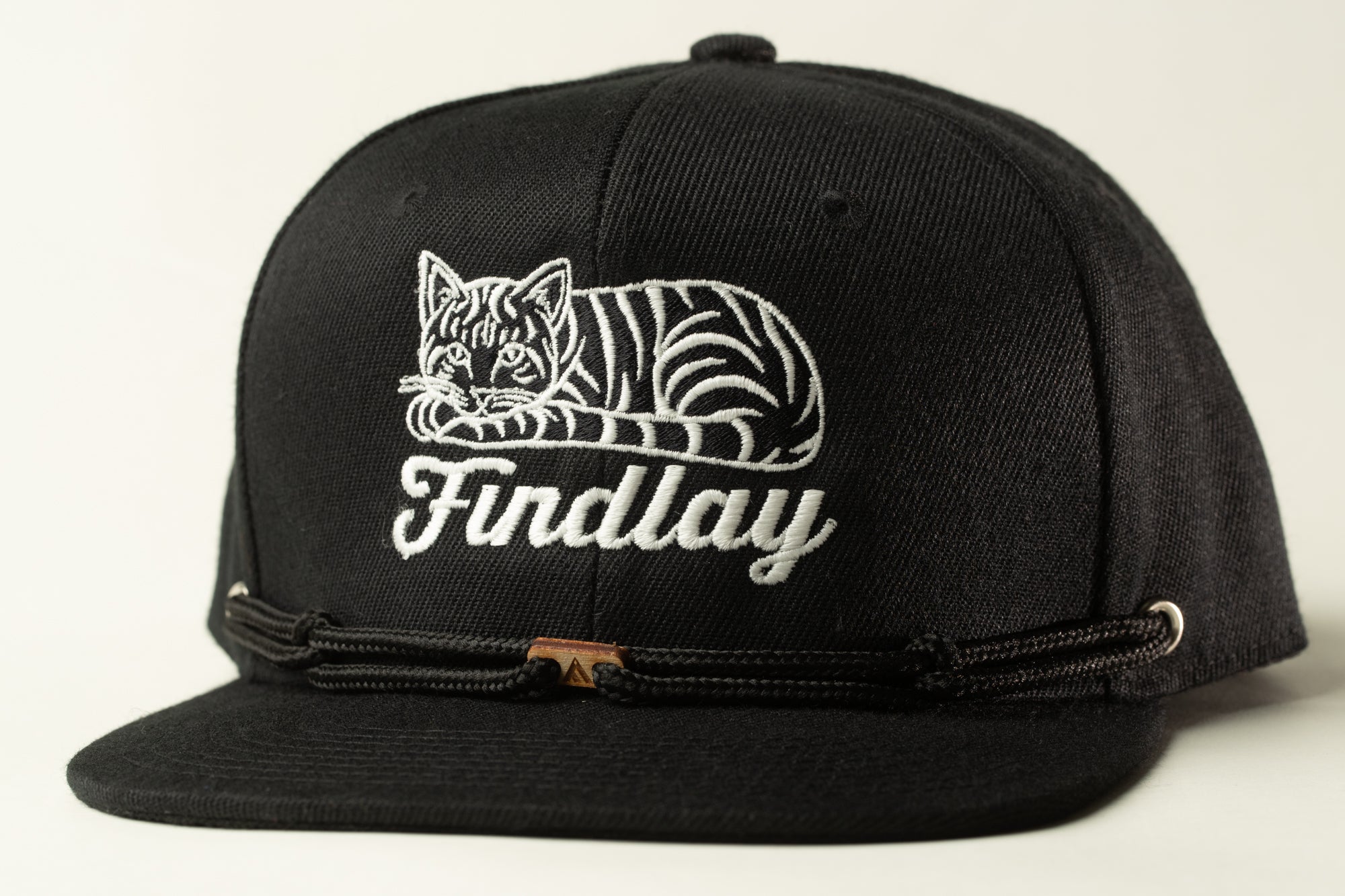 A black baseball cap with a white cat embroidered on it.