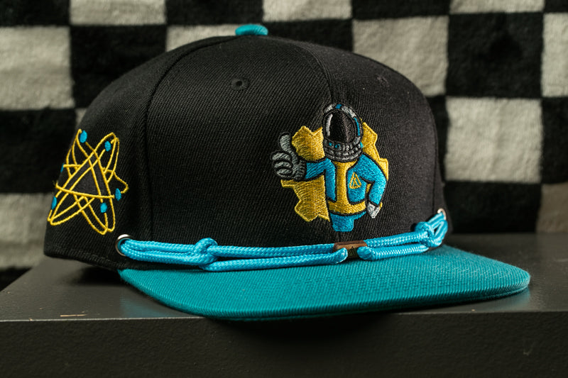 A black baseball cap with a yellow and blue design, featuring an embroidered image of a person in a blue suit and helmet.