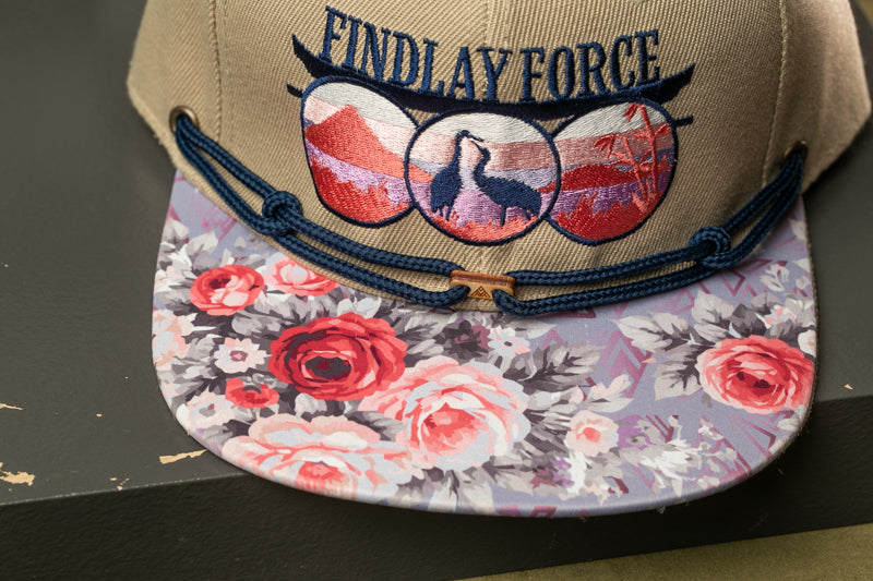 A baseball cap with a floral pattern and the text "FINDlay Force" printed on it.