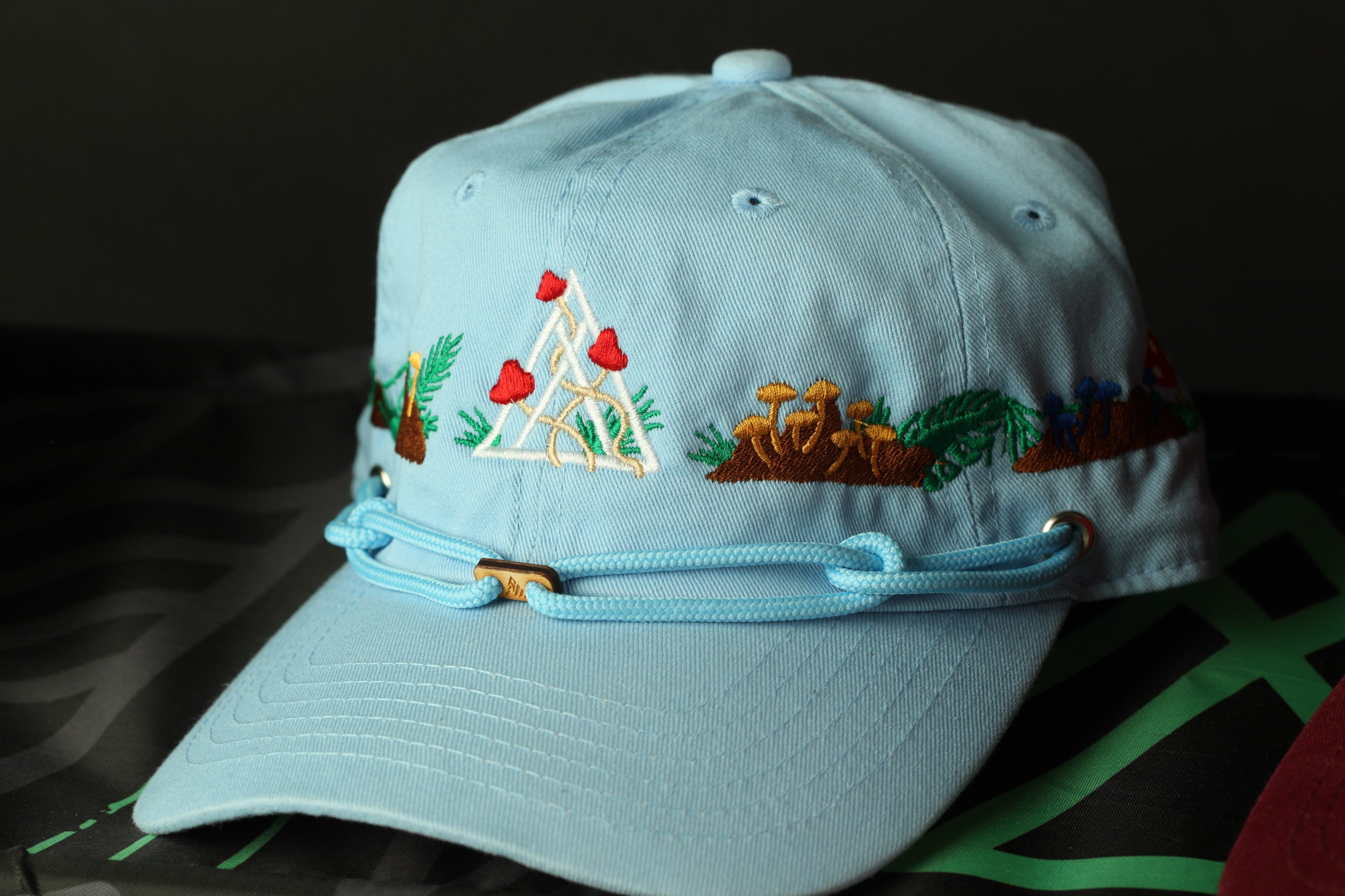 A light blue baseball cap with a floral pattern and a triangular design on the front.
