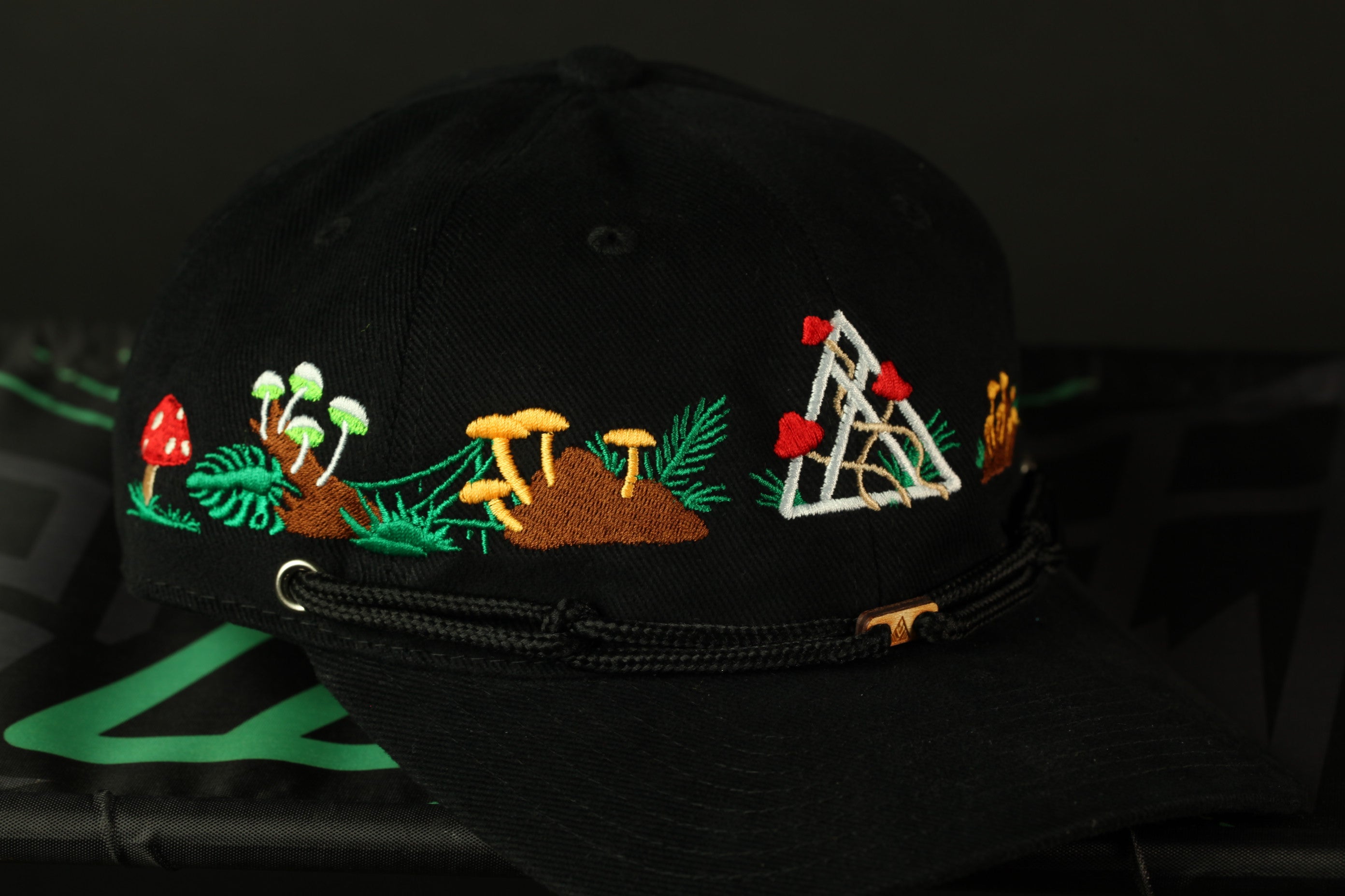 A black baseball cap with colorful floral and geometric embroidery designs on the brim.