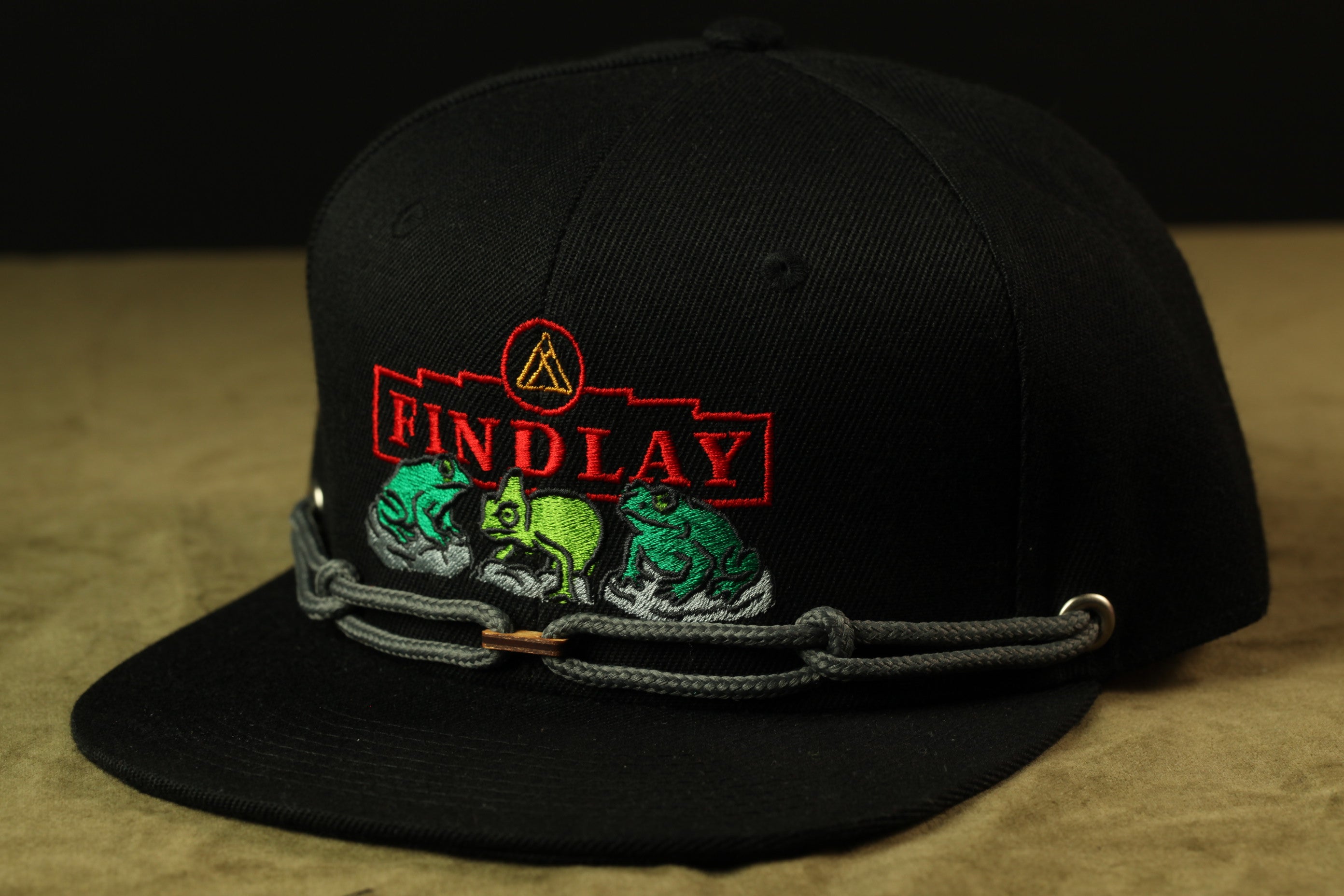 A black baseball cap with a red and green embroidered logo on the front.