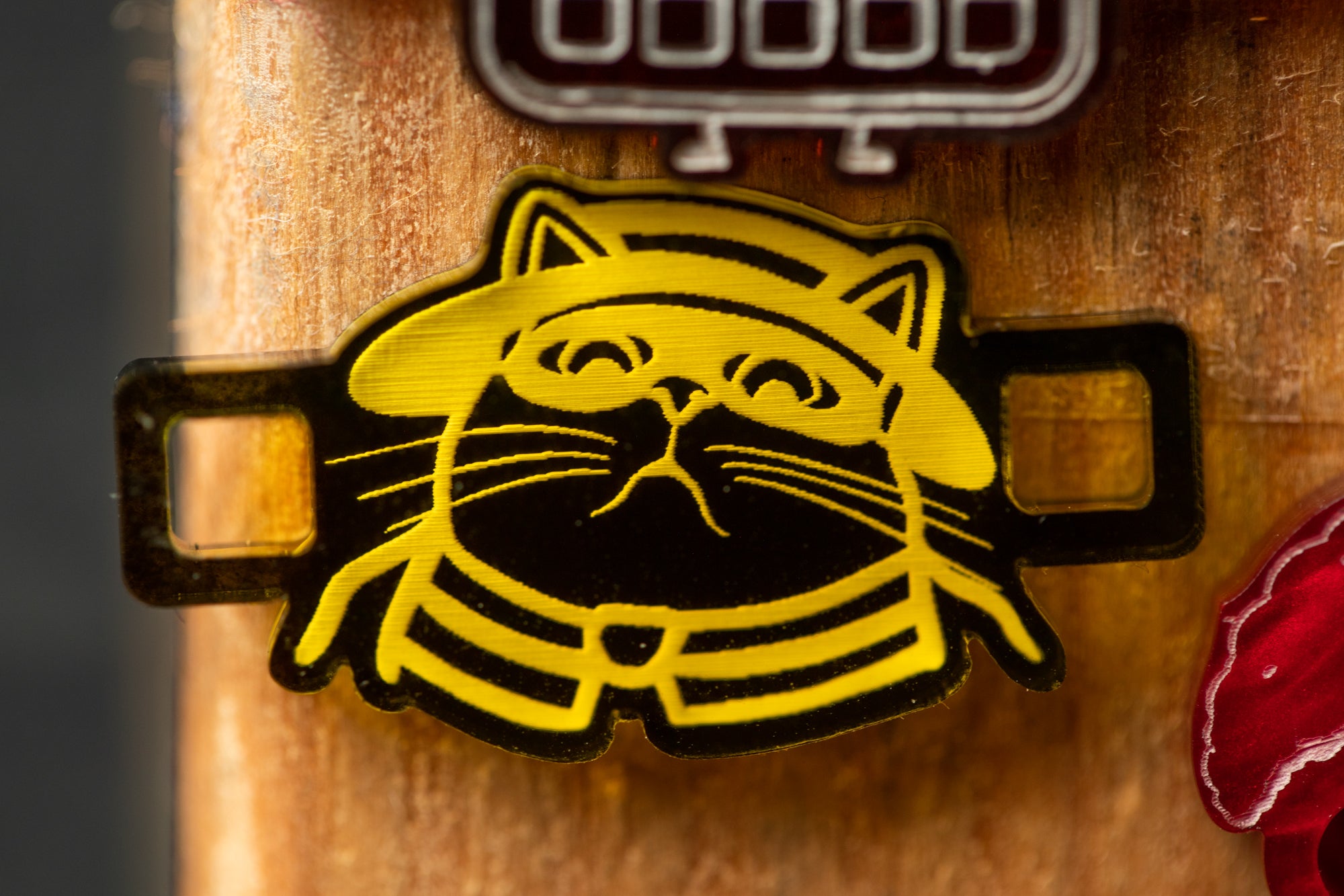 A close-up image of a cat-shaped object with a yellow and black design, featuring a cat's face with a hat and collar.