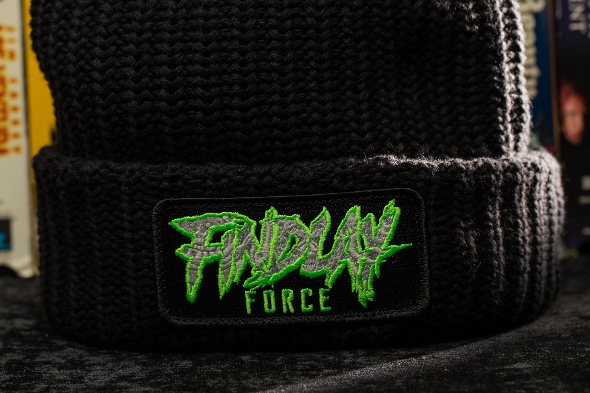 a black beanie with green graffiti on it