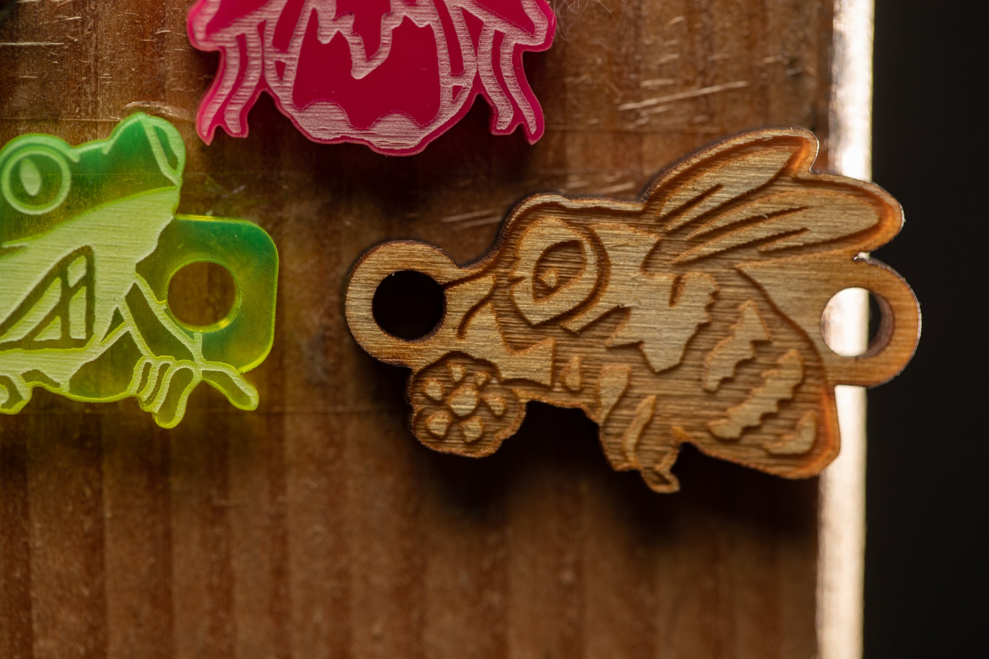 a close up of three wooden magnets on a wooden surface