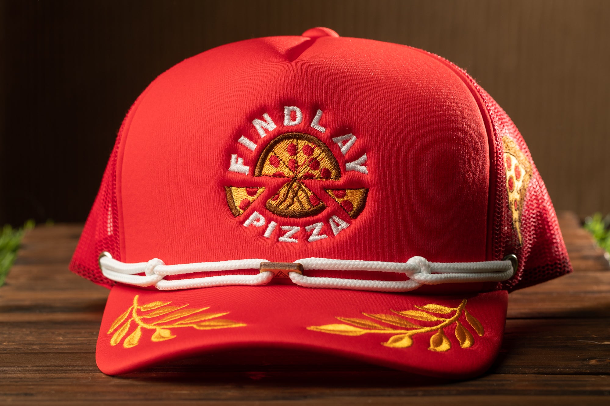 A red baseball cap with the logo of Findlay Pizza on it.