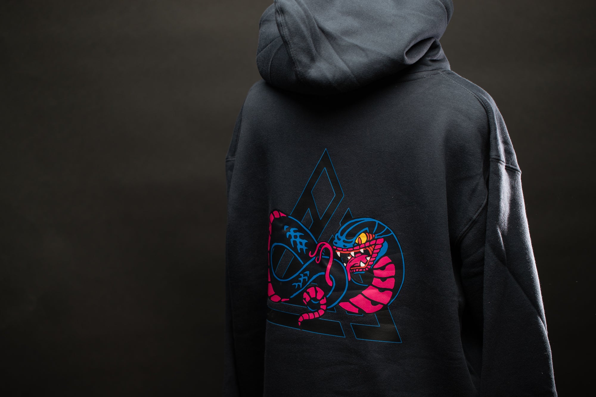 a person wearing a black hoodie with a dragon on it