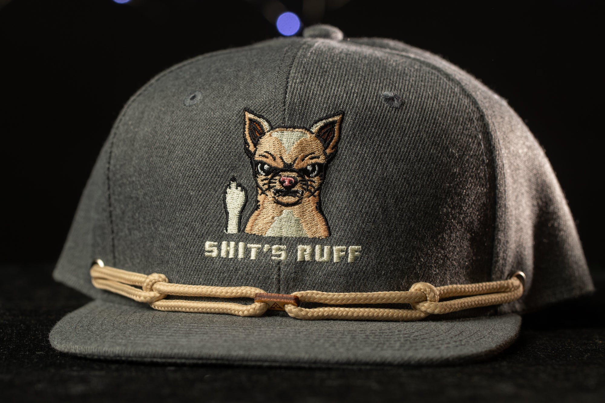 A gray baseball cap with a cartoon dog and the text "SHIT'S RUFF" printed on it.