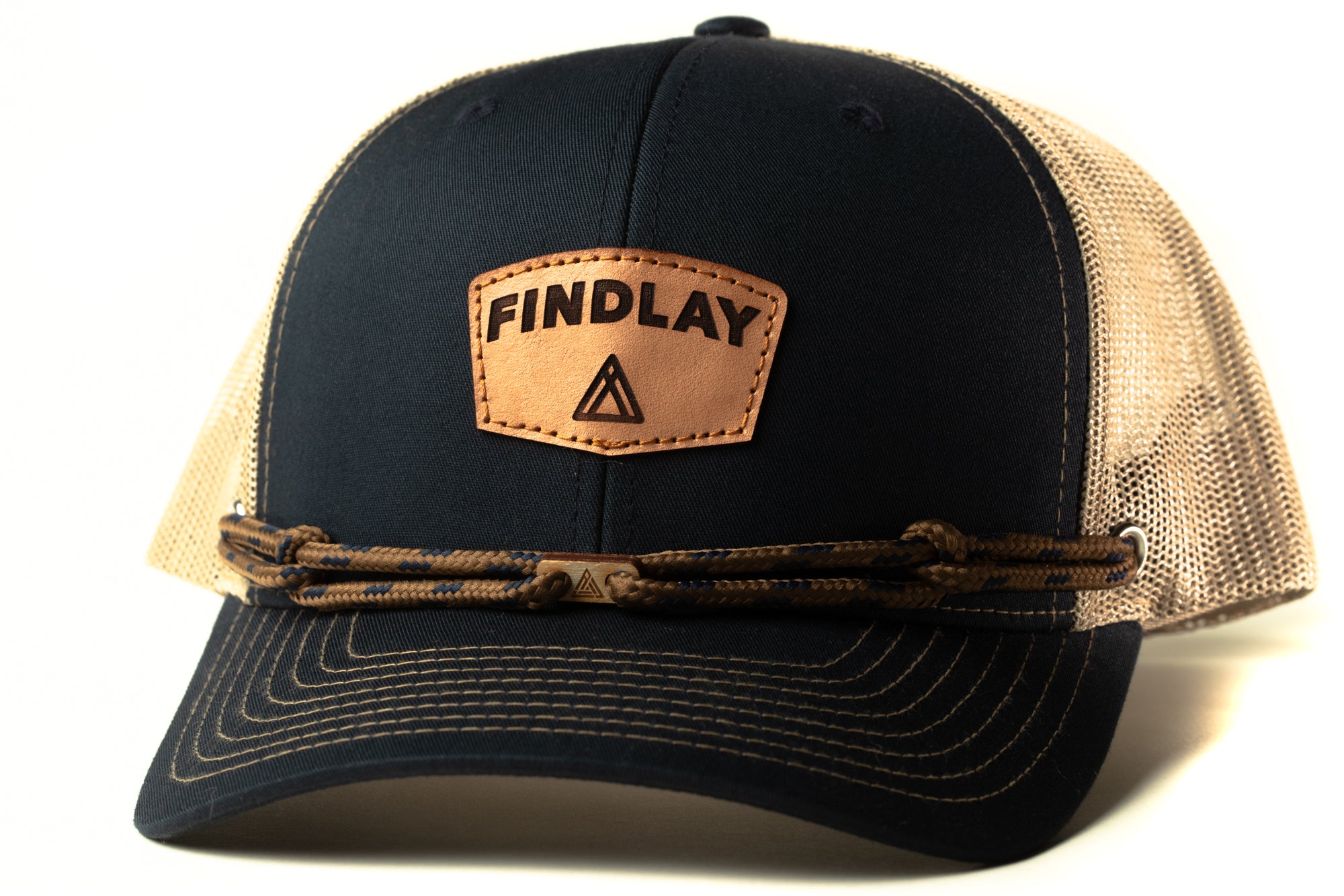 A black baseball cap with a tan mesh panel and a leather patch on the front, featuring the text "FINDLAY" and a triangle symbol.