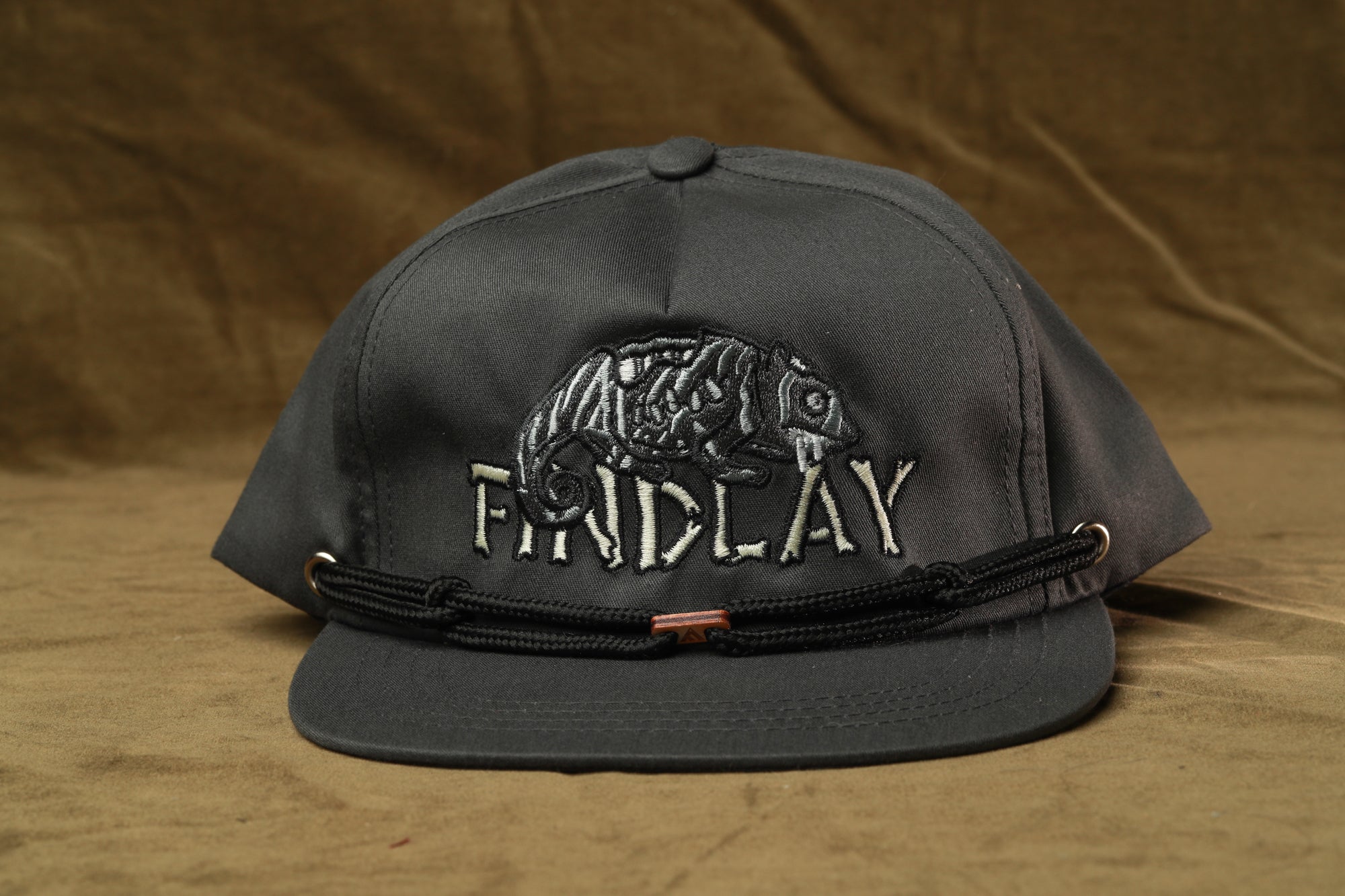 A black baseball cap with a white embroidered logo on the front.