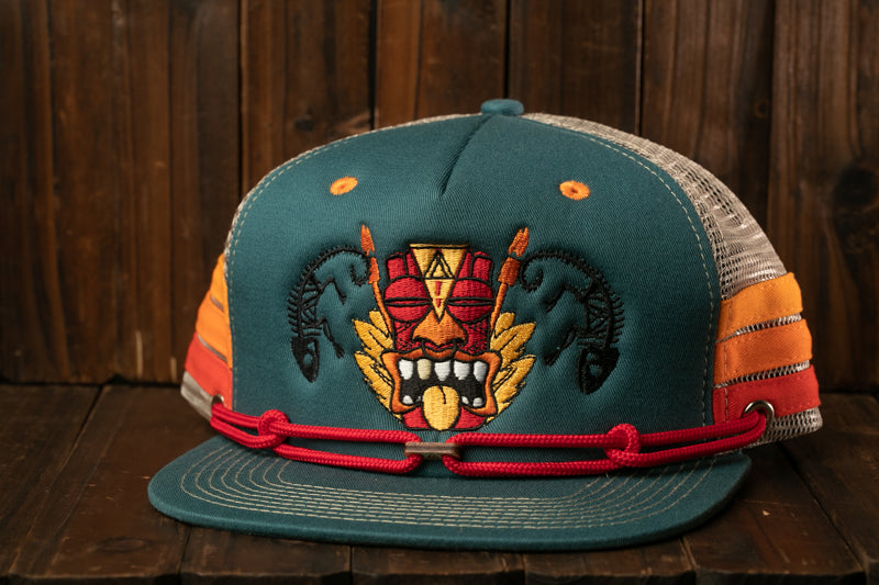 A colorful baseball cap with a graphic design on the front, featuring a mask-like figure with a red and yellow pattern.