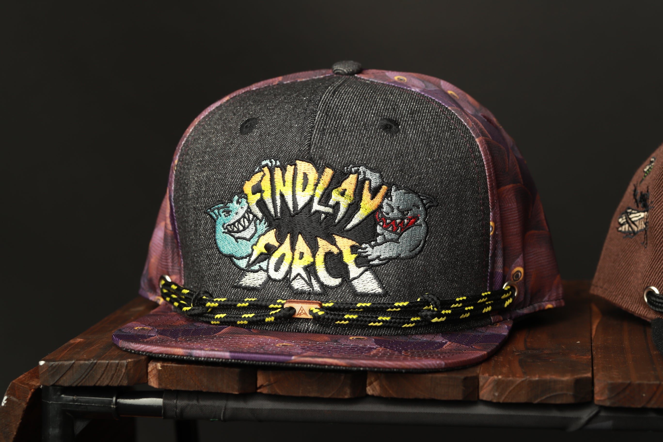 A black baseball cap with a colorful, cartoonish design featuring a character and the text "ENDLAY FORCE" on it.