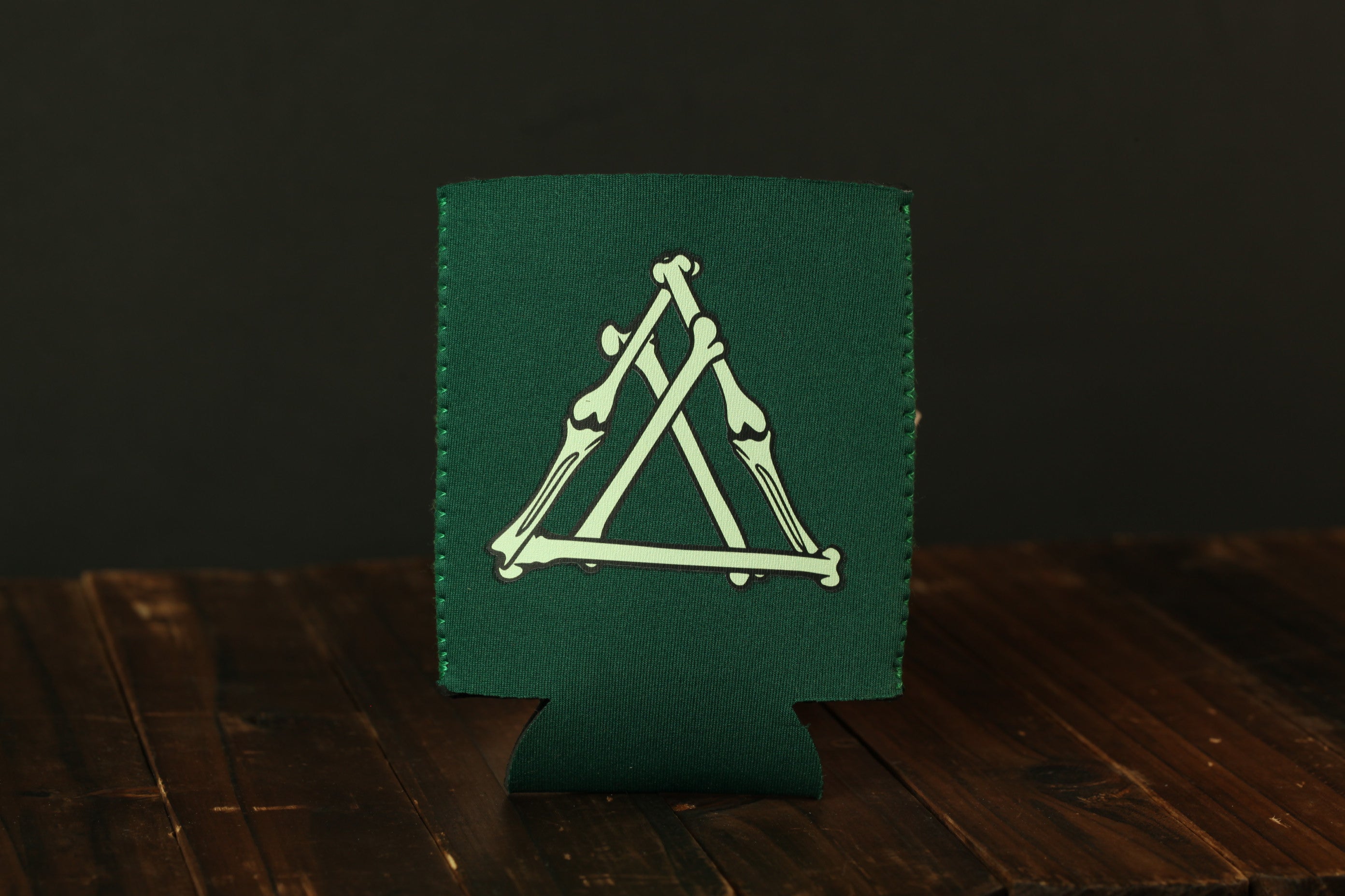 A green cooler with a white graphic design on it, placed on a wooden surface.