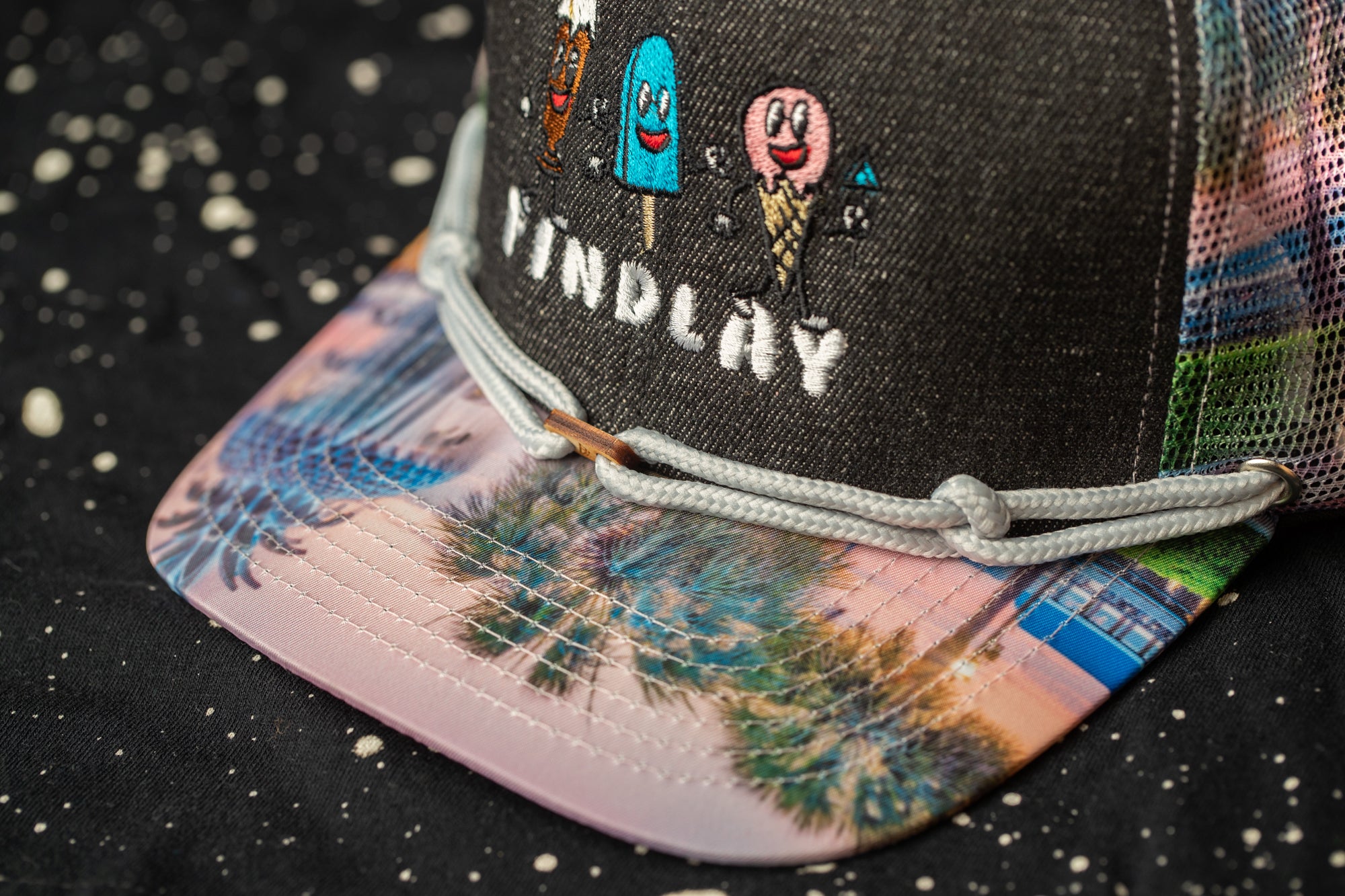A close-up view of a colorful baseball cap with a printed design on the front.