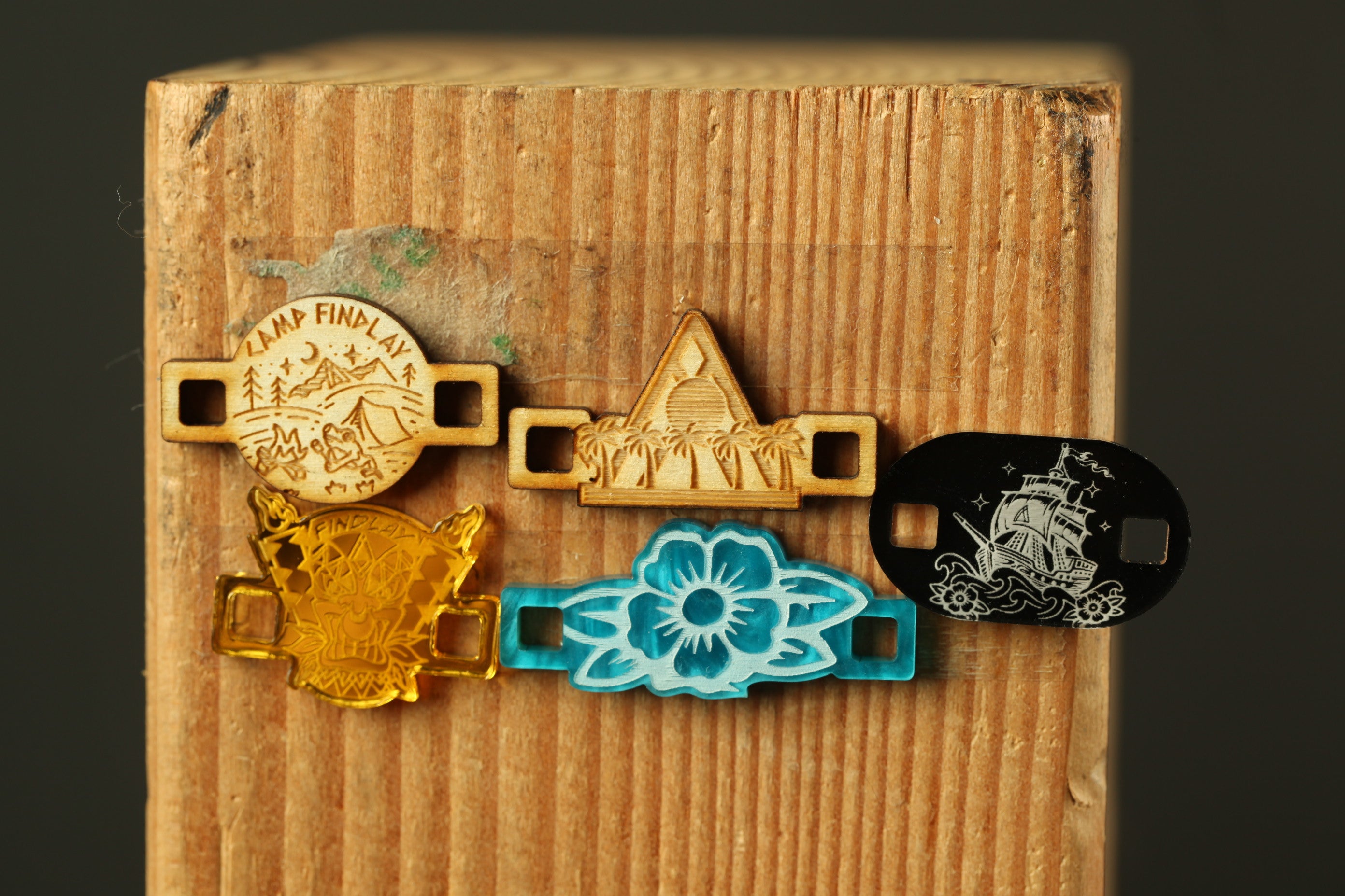 a collection of five different wooden pieces, each with unique designs and patterns, attached to a wooden surface.