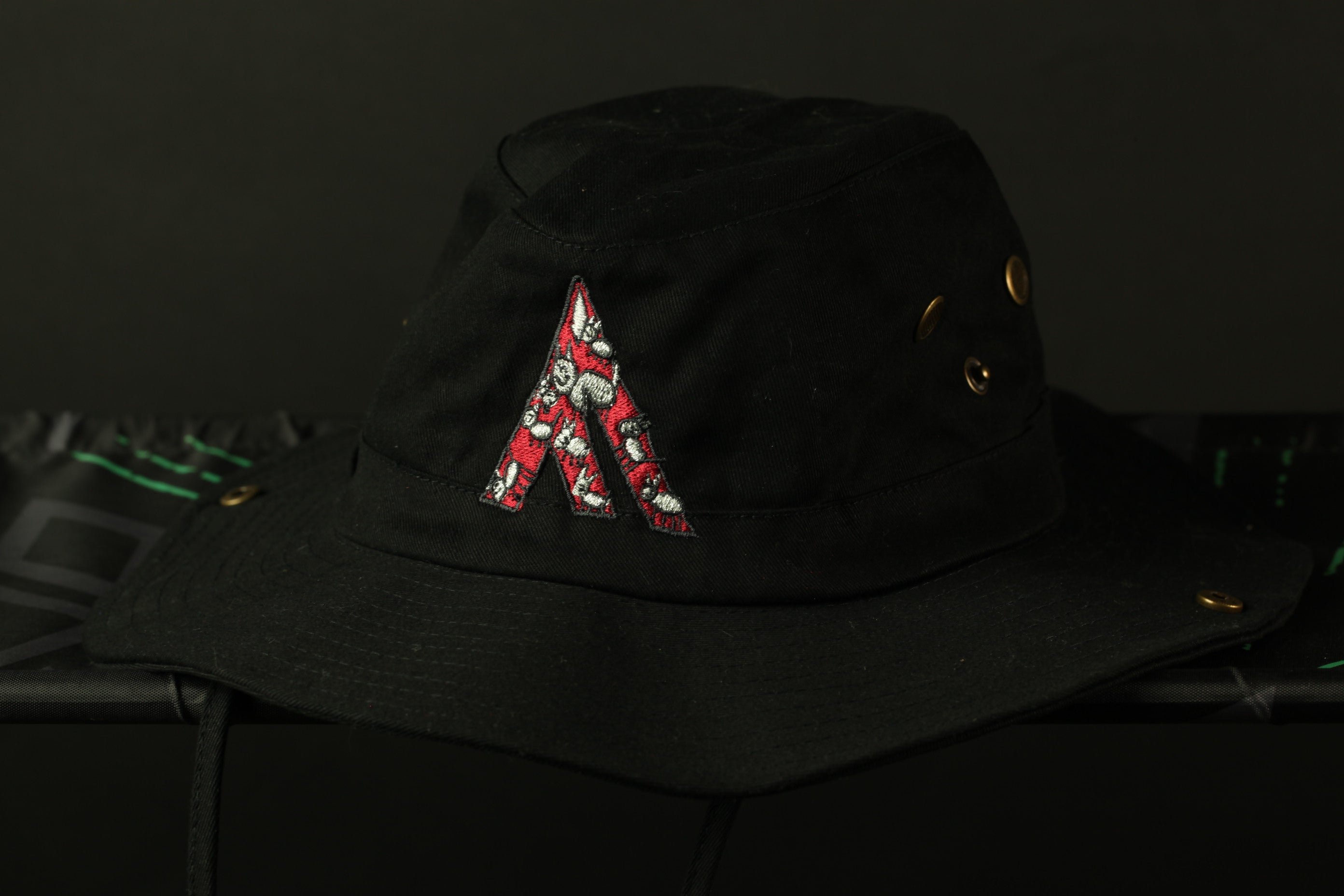 A black bucket hat with a red floral pattern on the front.