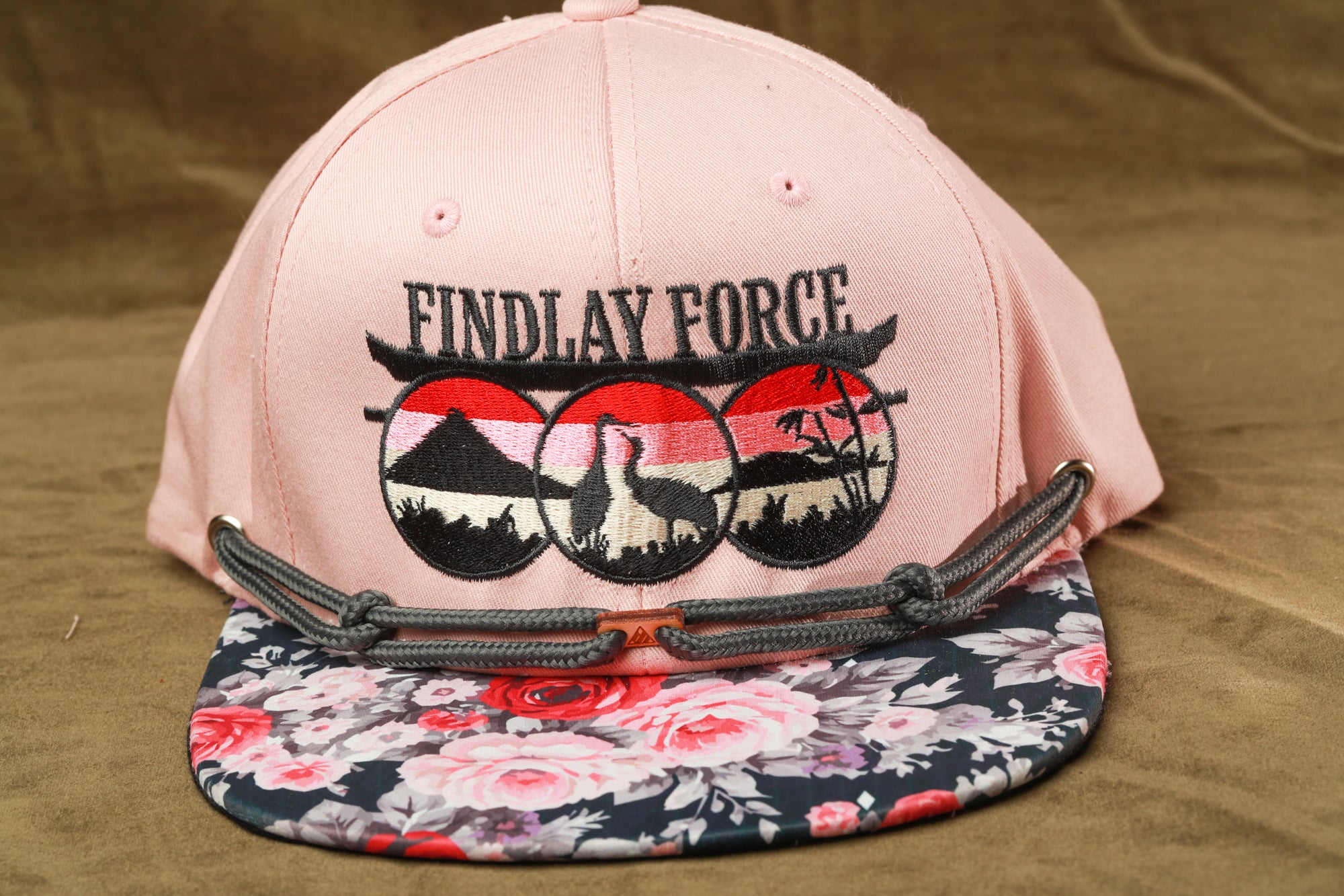 A pink baseball cap with a floral pattern and the text "FINDLAY FORCE" printed on it.