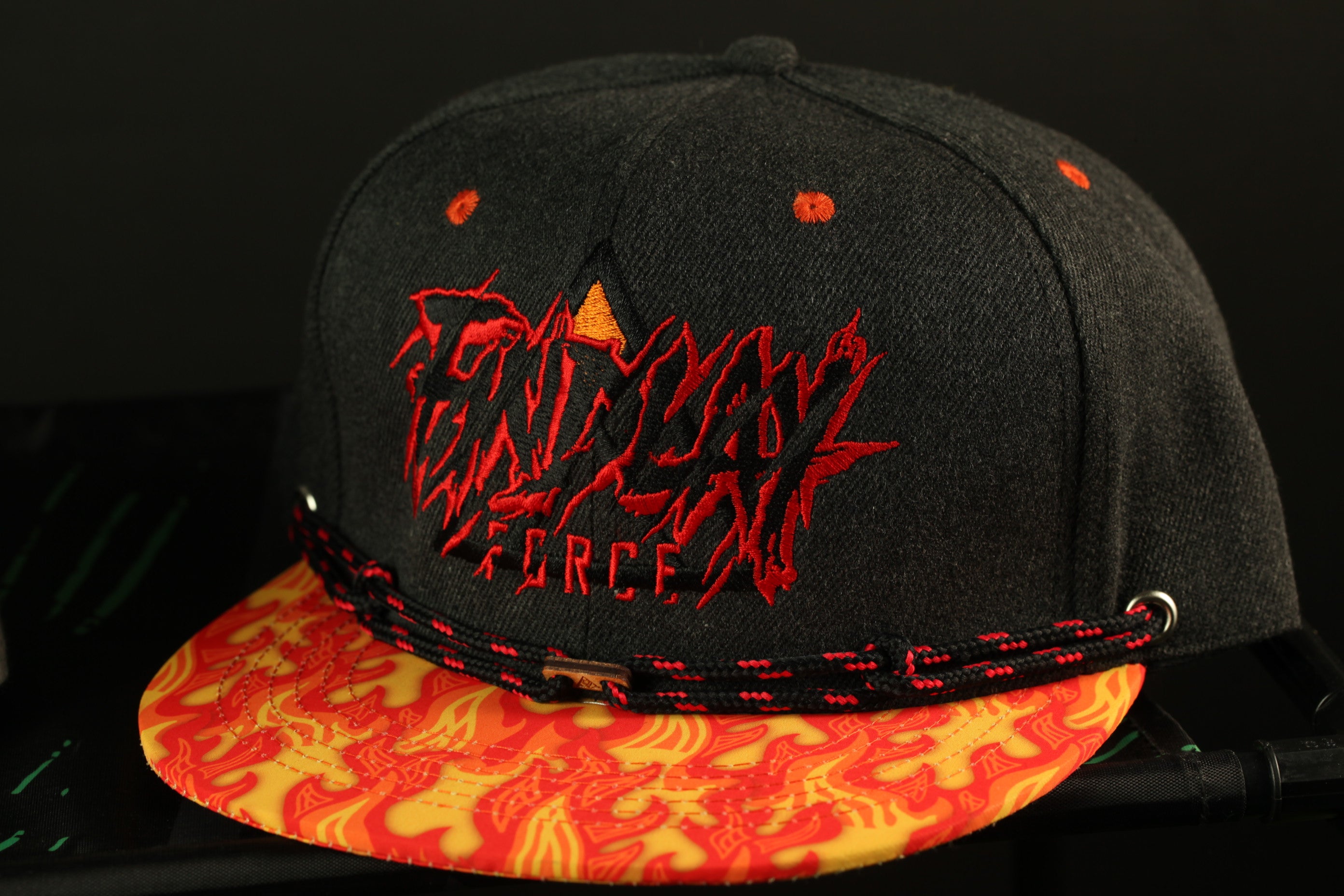 A black baseball cap with a flame-designed brim and the word "FANTASY" printed on it.