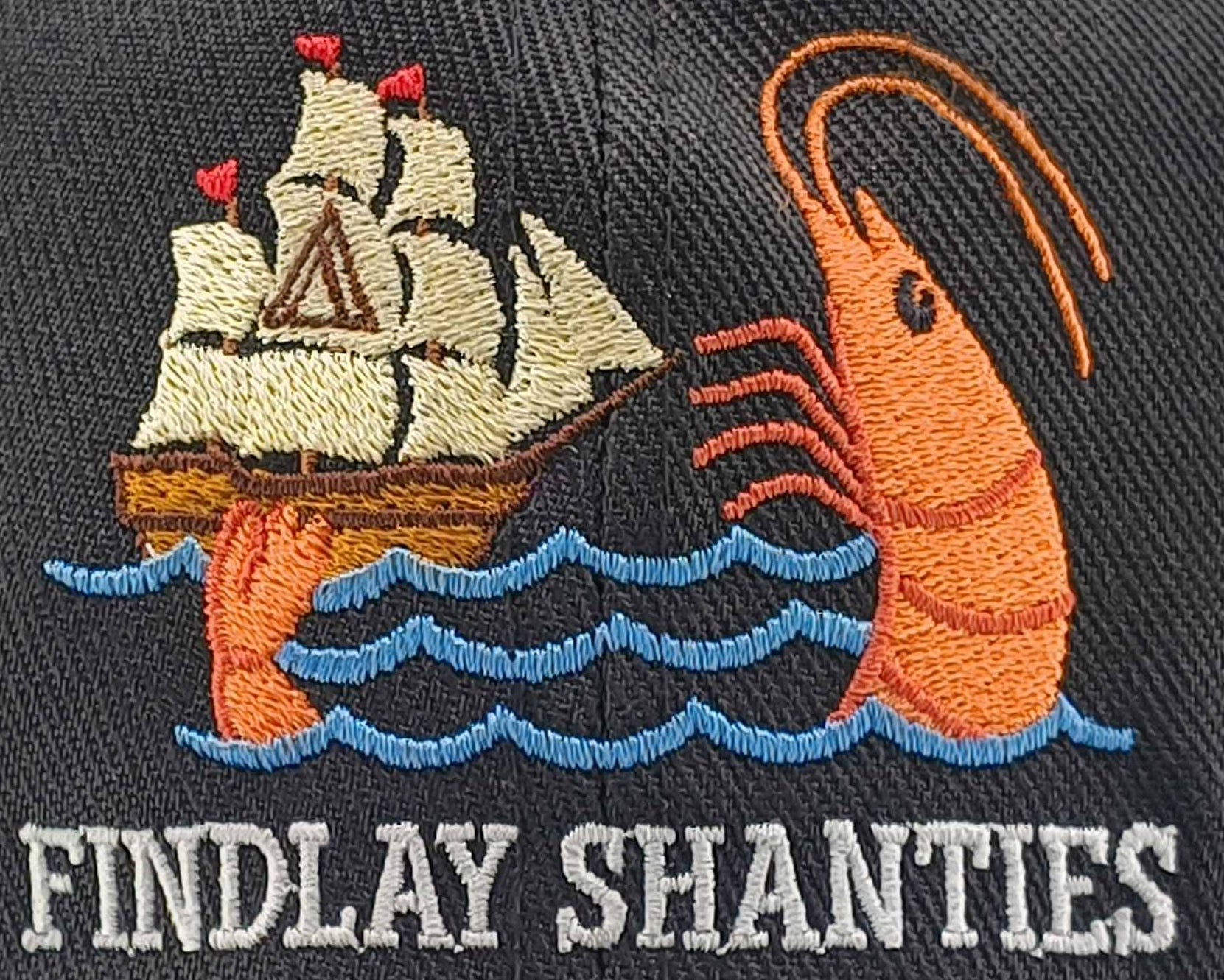 a hat with a picture of a shrimp and a ship