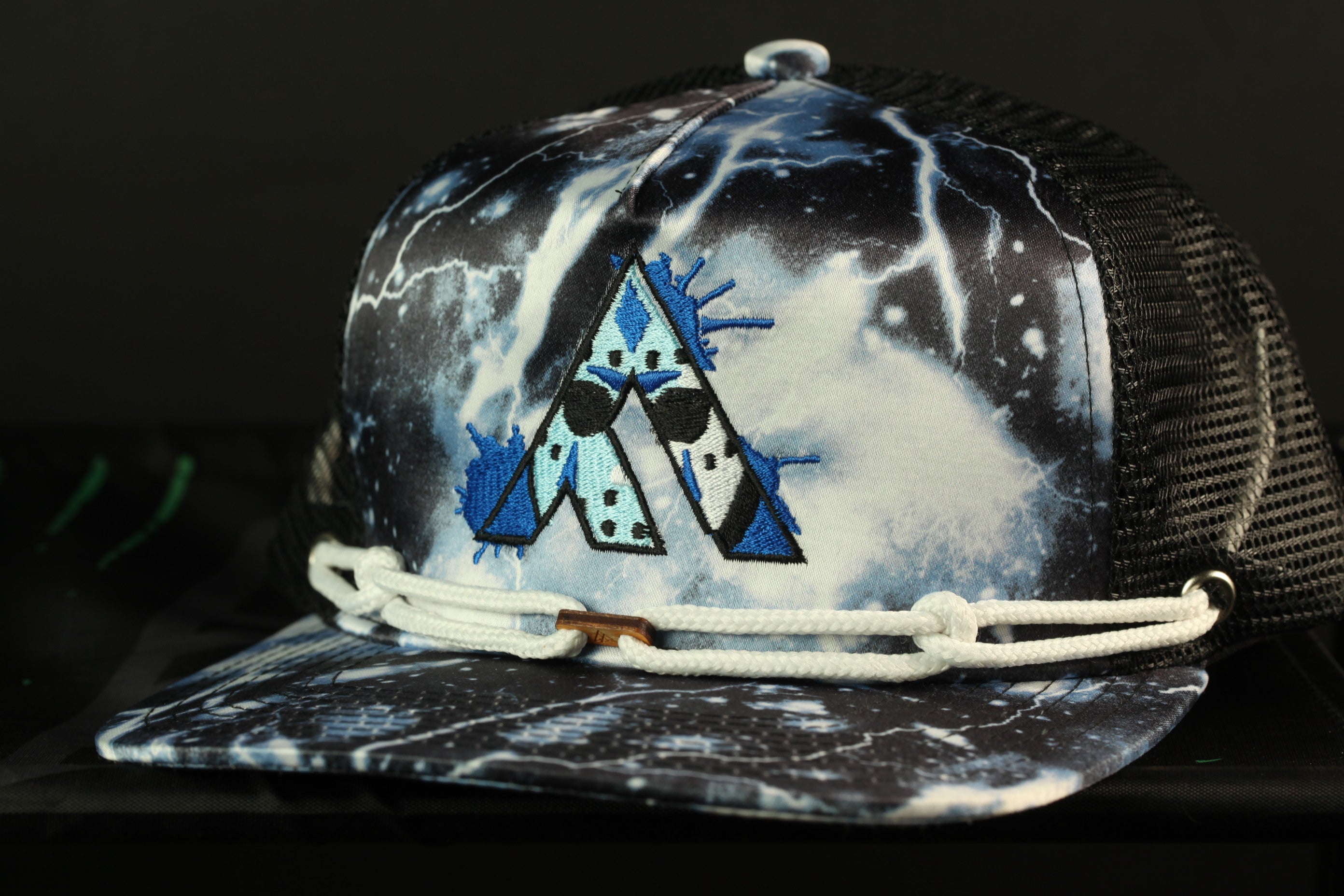 A black and white baseball cap with a unique graphic design on the front.