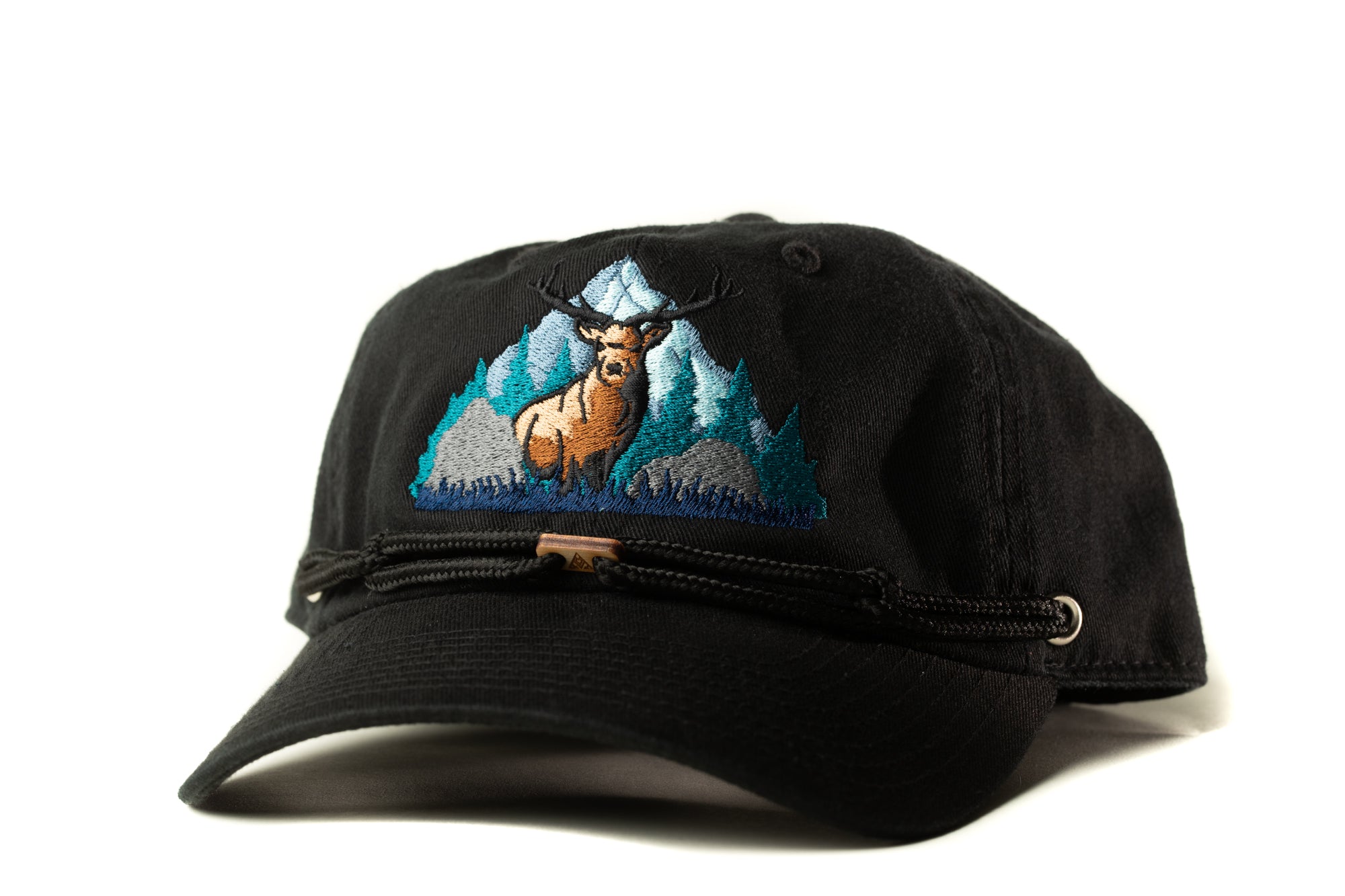 A black baseball cap with a detailed embroidered design depicting a deer standing in a mountainous landscape.