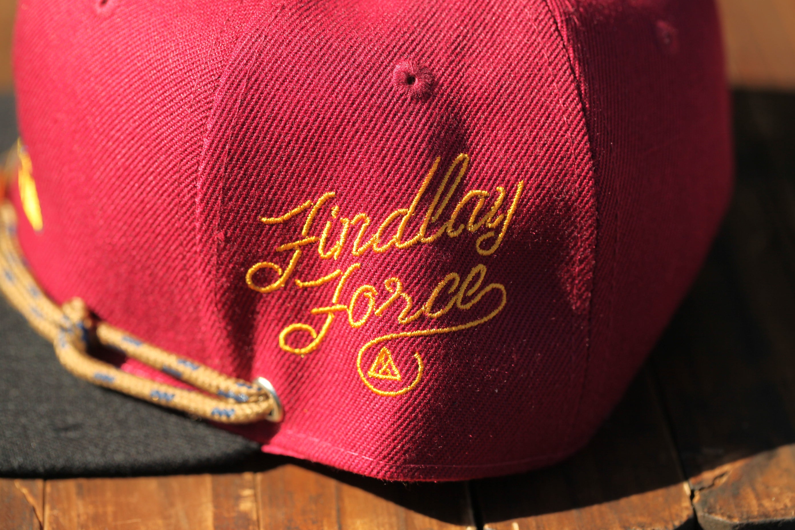 A close-up view of a red baseball cap with the text "Findlay Force" embroidered on it.