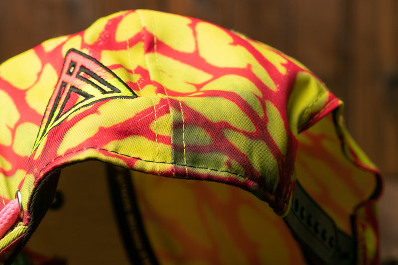 A close-up view of a colorful, patterned fabric, possibly a hat or cap, with a distinctive logo or design on the left side.
