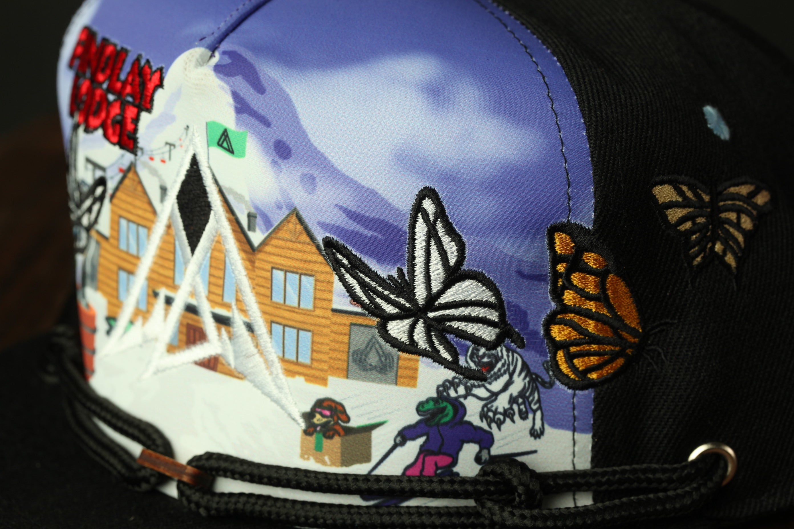 a colorful, embroidered cap with various scenes and characters depicted on it.