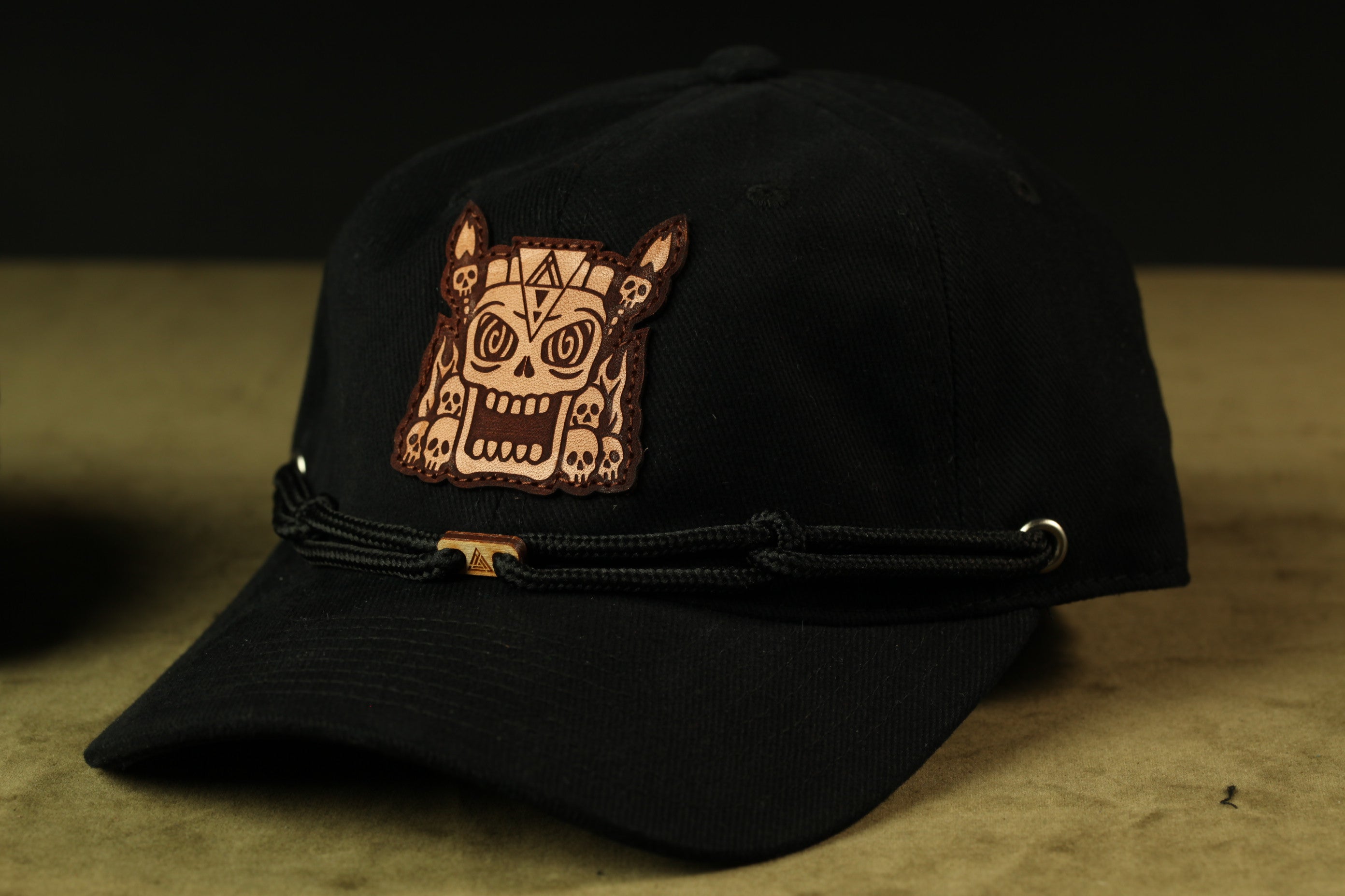 A black baseball cap with a skull patch on the front.