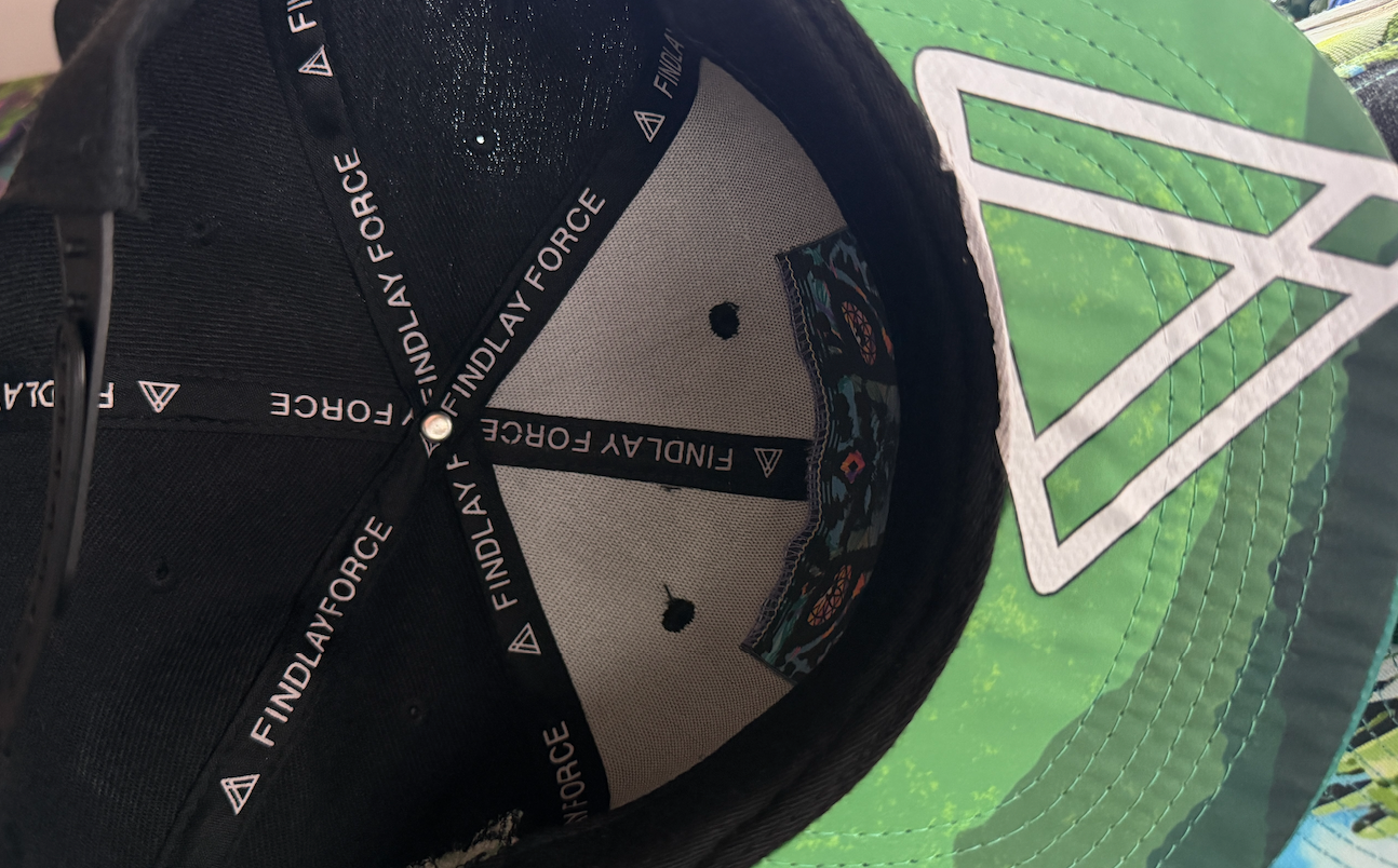 the interior of a black baseball cap with a white logo on the brim.