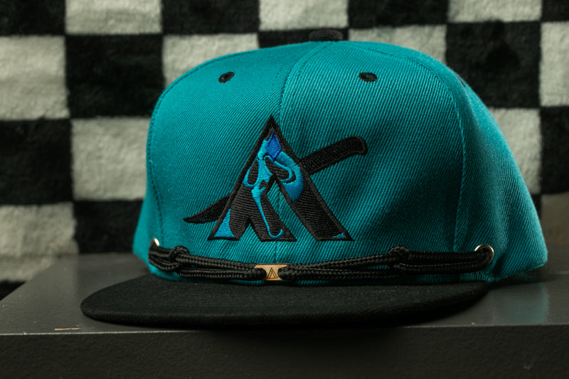 A turquoise baseball cap with a black brim and a black strap, featuring a logo on the front.