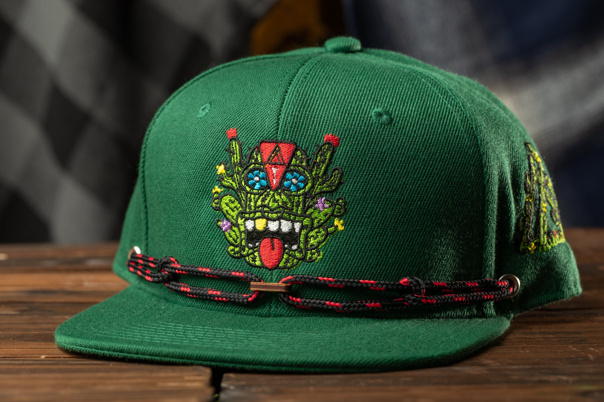 A green baseball cap with a colorful, embroidered design on the front.