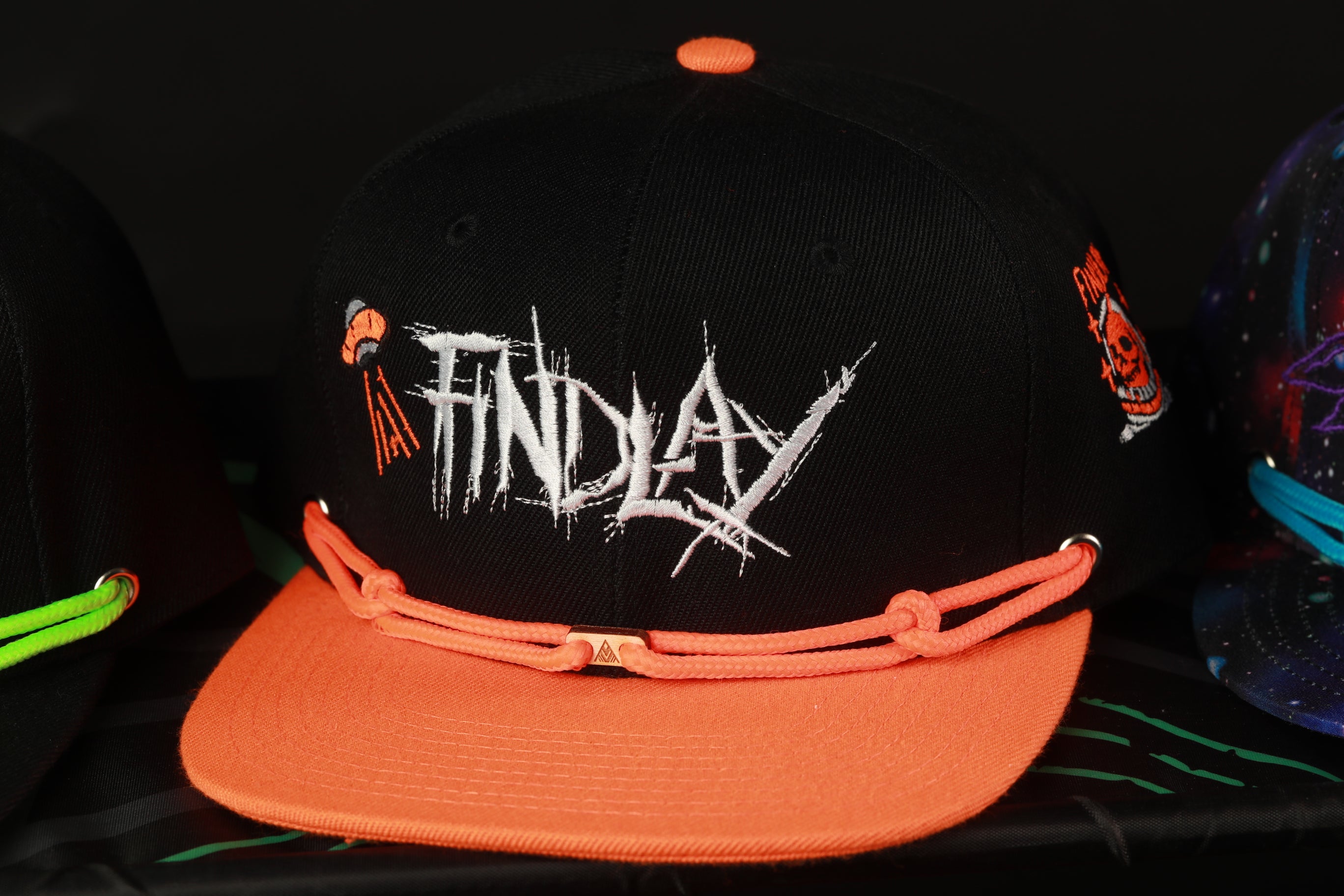 A black baseball cap with an orange brim, featuring the word "FINDAY" in white text on the front.