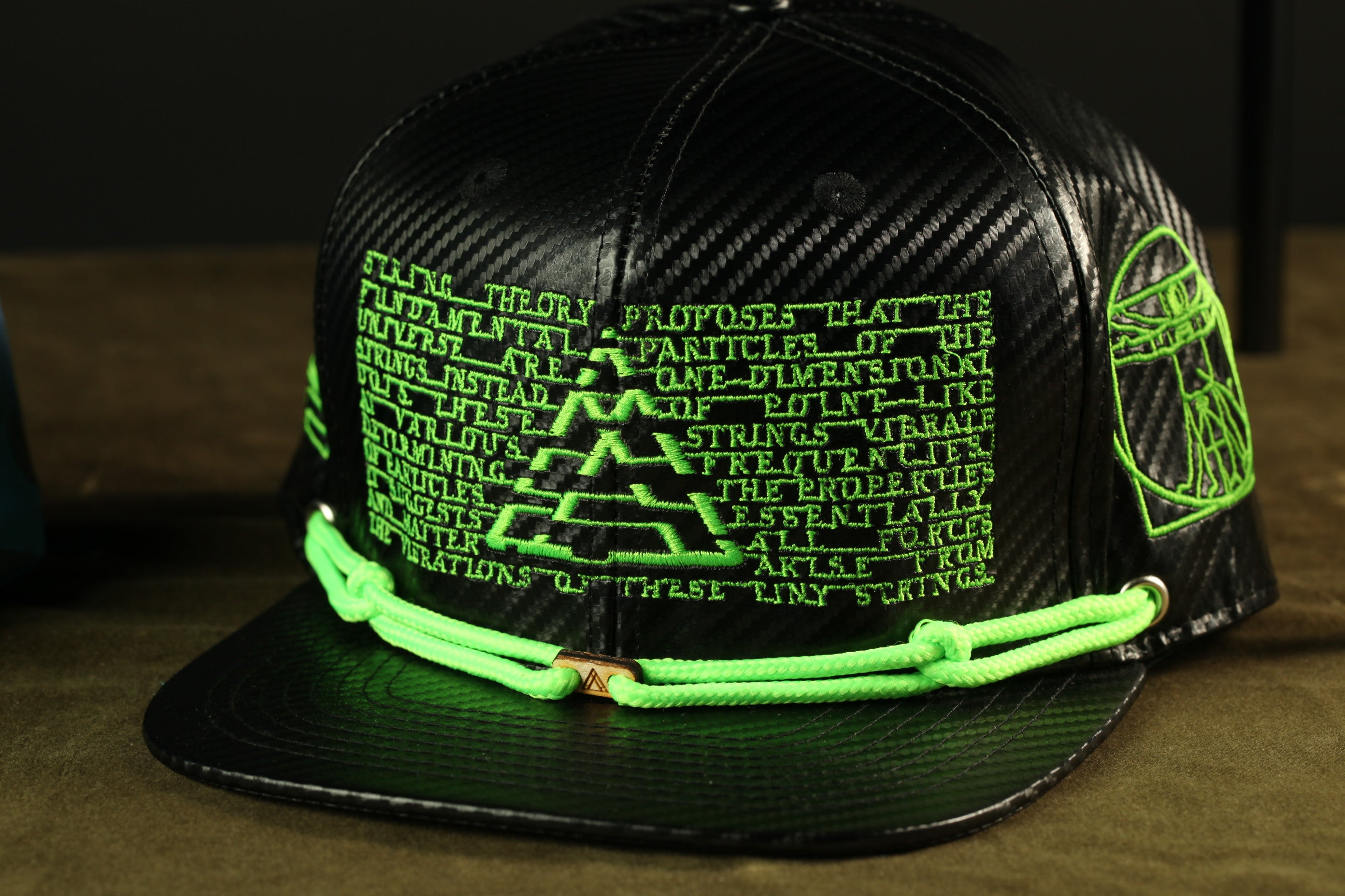 A black baseball cap with green text and graphics on it.