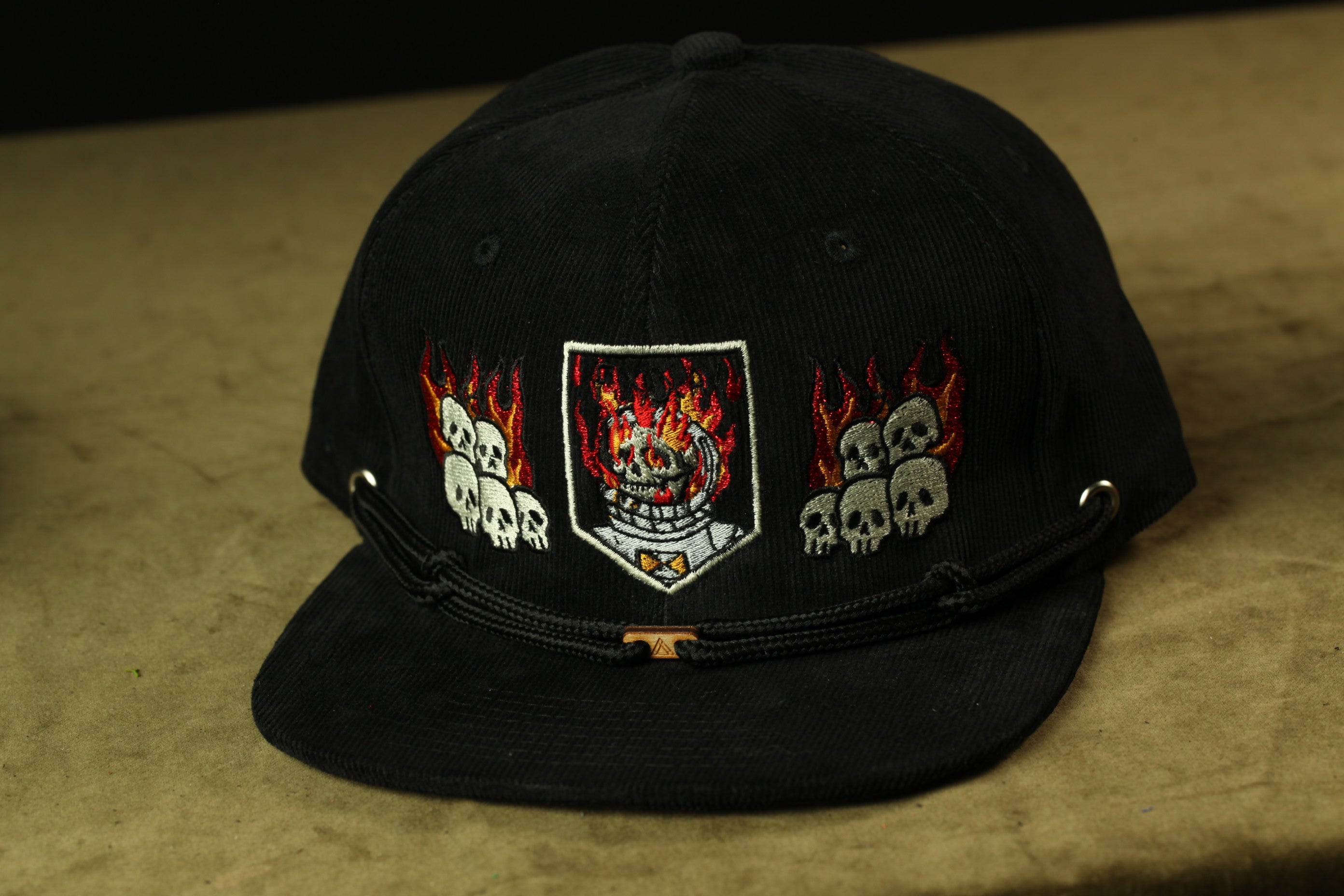 A black baseball cap with a graphic design featuring a skull and flames on the front.
