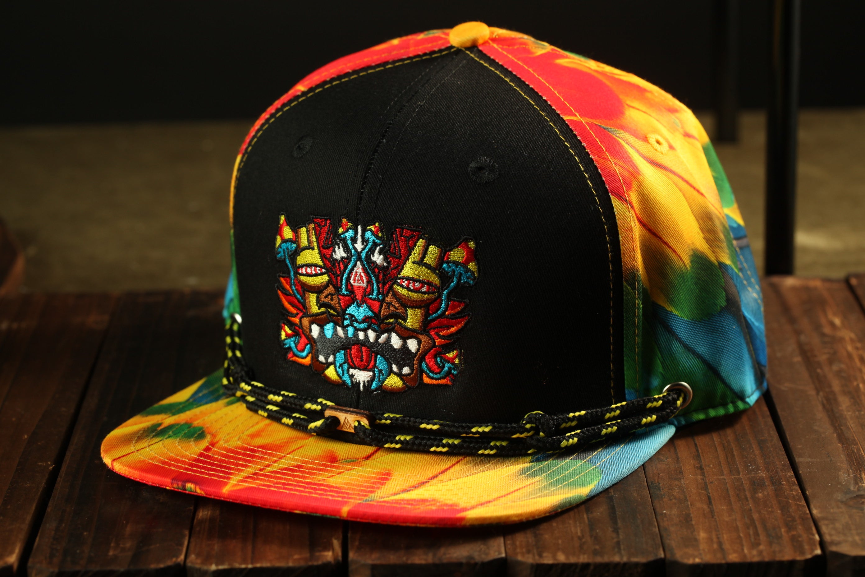 A colorful tie-dye baseball cap with a black brim and a vibrant, abstract design on the front.