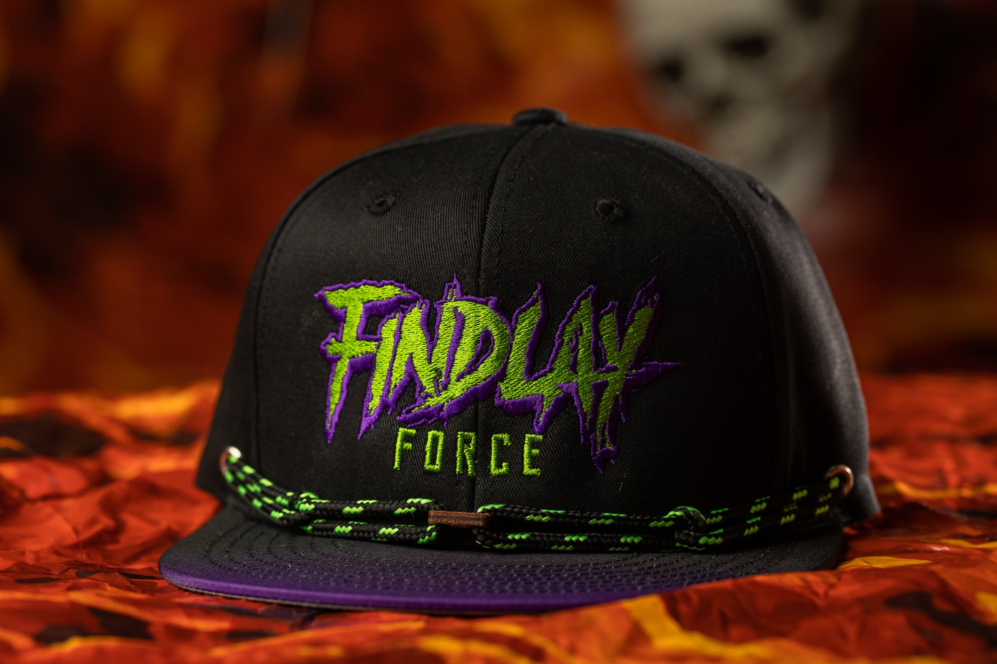 A black baseball cap with the text "FIND LAY FORCE" printed on it, along with a green and purple design.