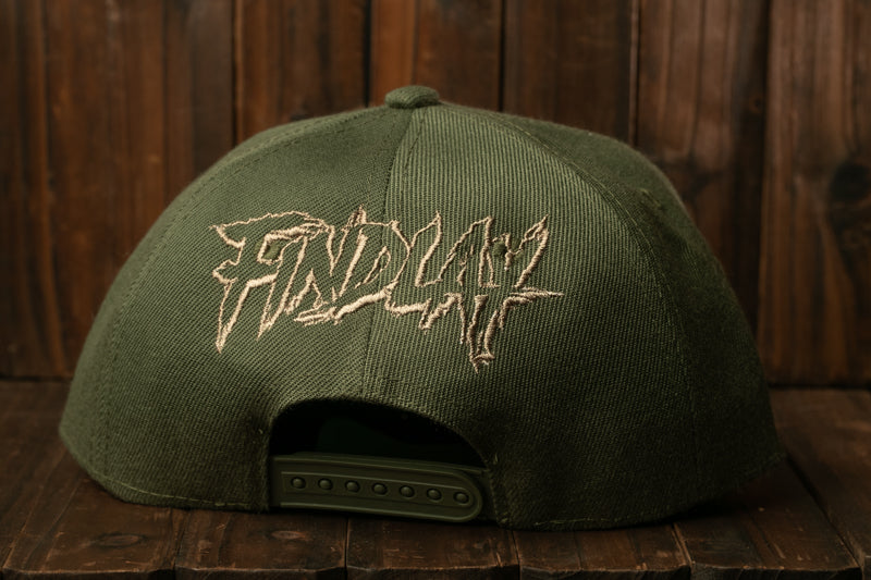 A green baseball cap with the word "FIND" embroidered on it, sitting on a wooden surface.