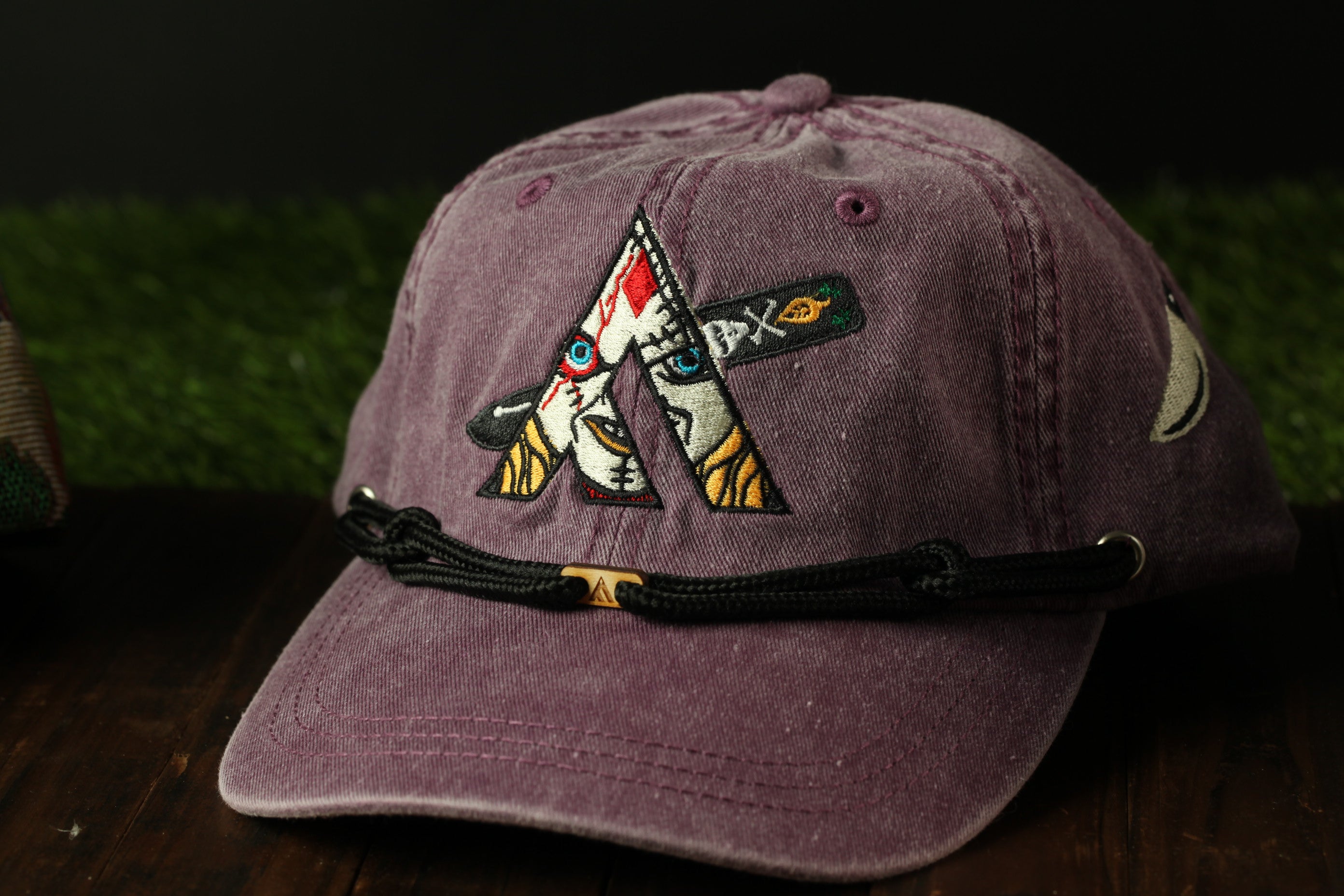 A purple baseball cap with a unique embroidered design on the front.