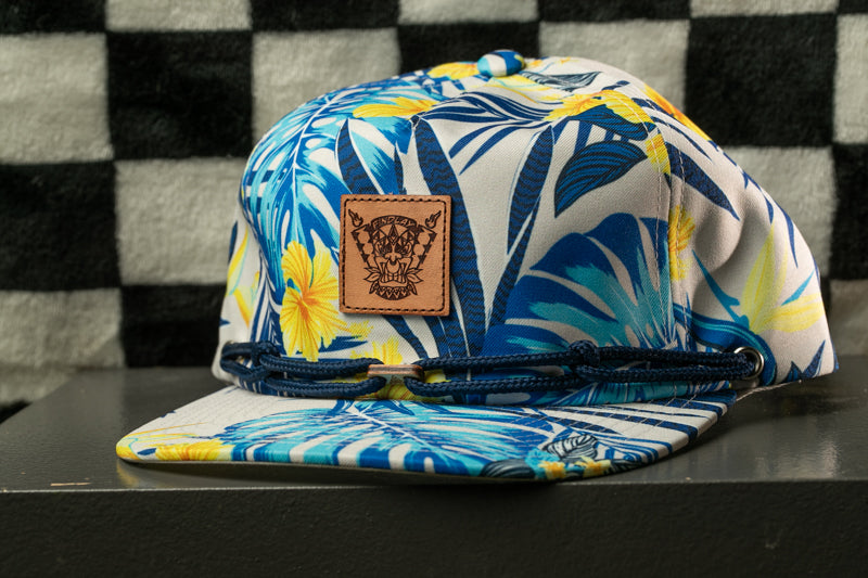 A colorful floral printed baseball cap with a leather patch on the front.