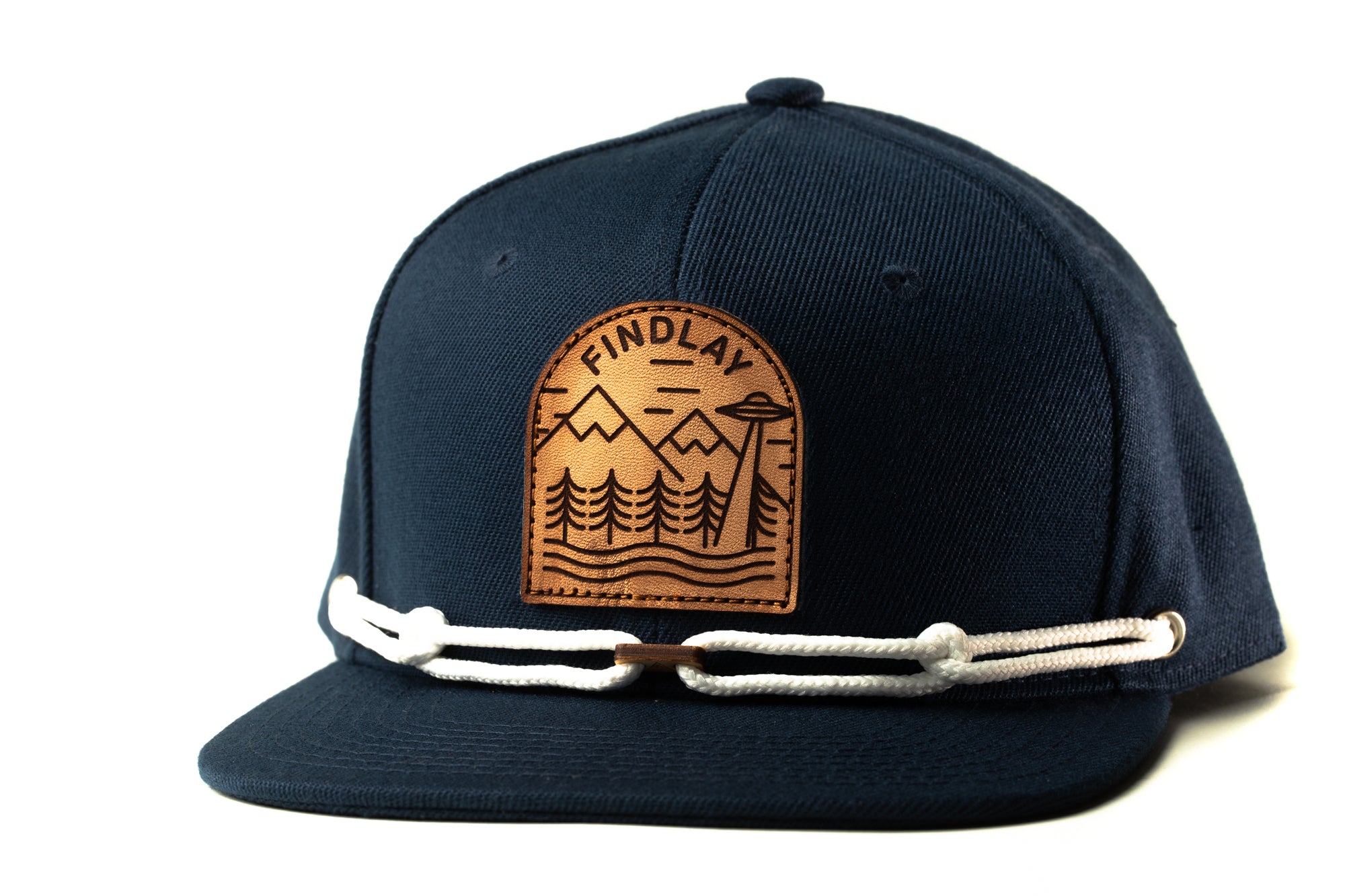 A navy blue baseball cap with a leather patch on the front that says "FINDLAY" and a mountain landscape design.