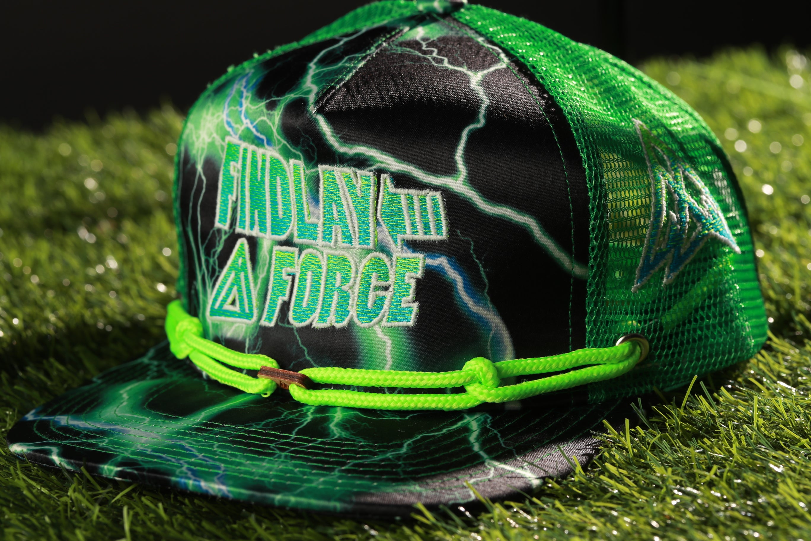 A green and black baseball cap with a lightning bolt design, featuring the text "FINDLAY FORCE" on the front.