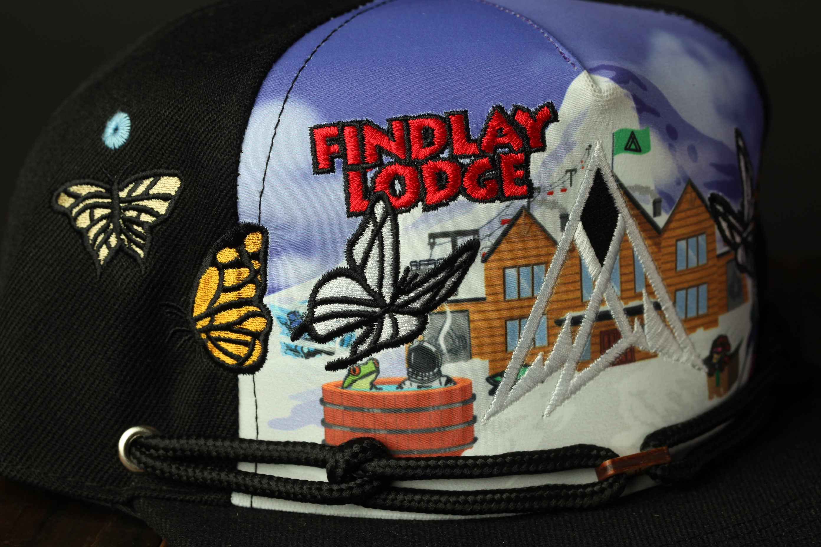 a close-up of a black baseball cap with a colorful embroidered design on the front.