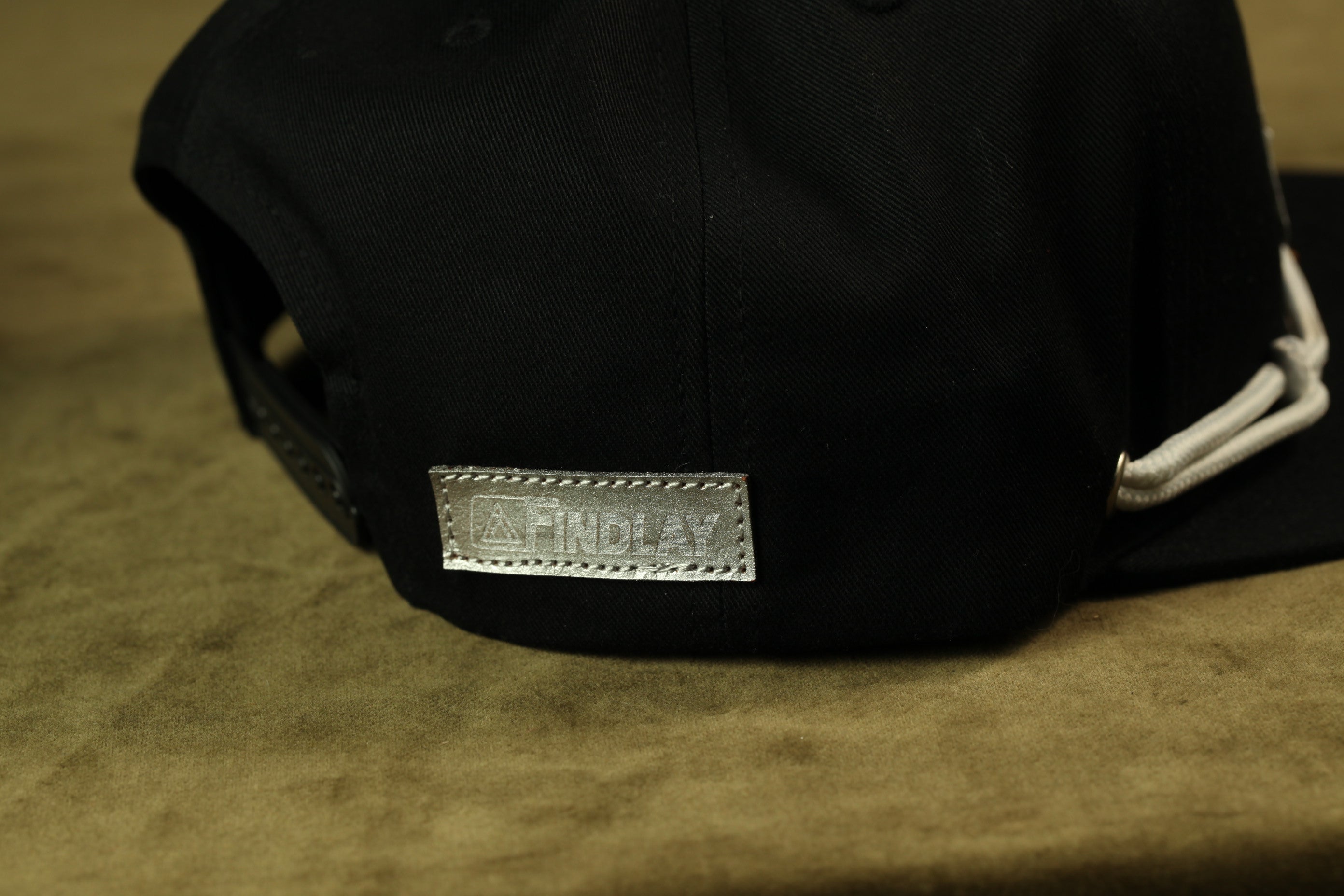 A black baseball cap with a white logo on the back.