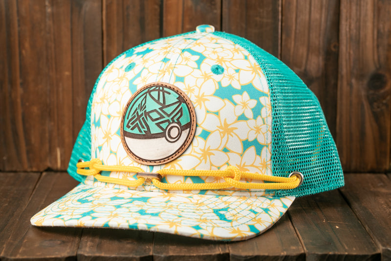 A colorful baseball cap with a floral pattern and a circular patch on the front, placed on a wooden surface.