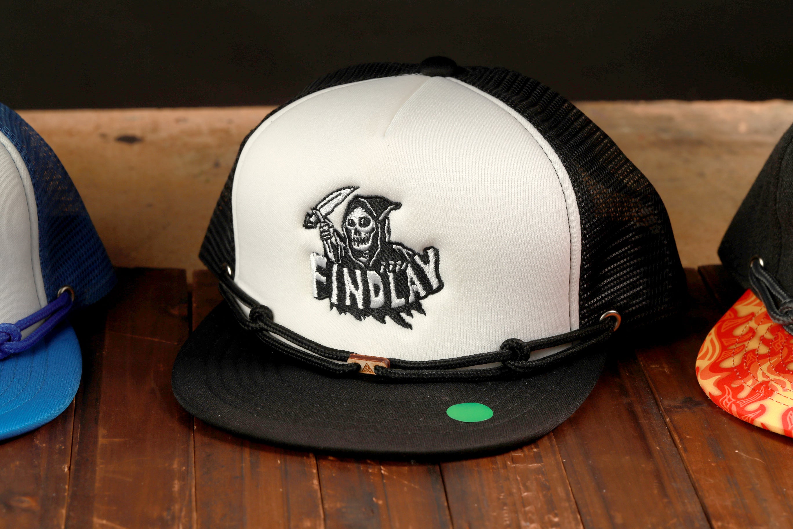 A black and white baseball cap with a skull and crossbones design, featuring the word "FINDlay" on the front.