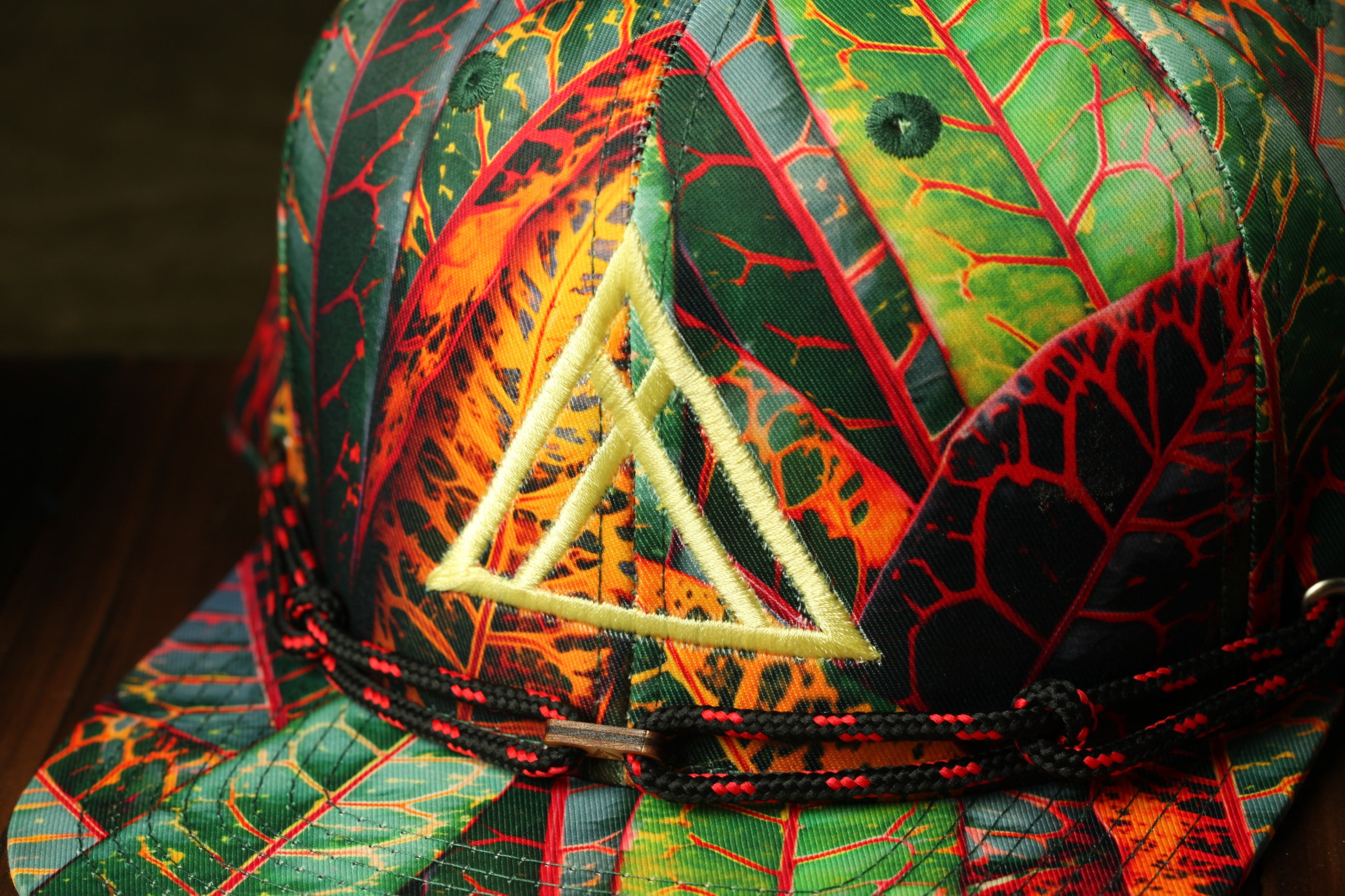 A colorful, patterned baseball cap with a distinctive triangle logo on the front.
